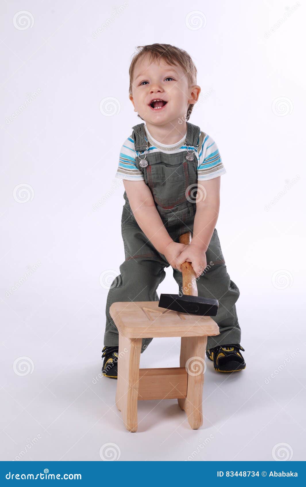 Petit Garçon Avec Le Marteau Et La Chaise En Bois Photo stock