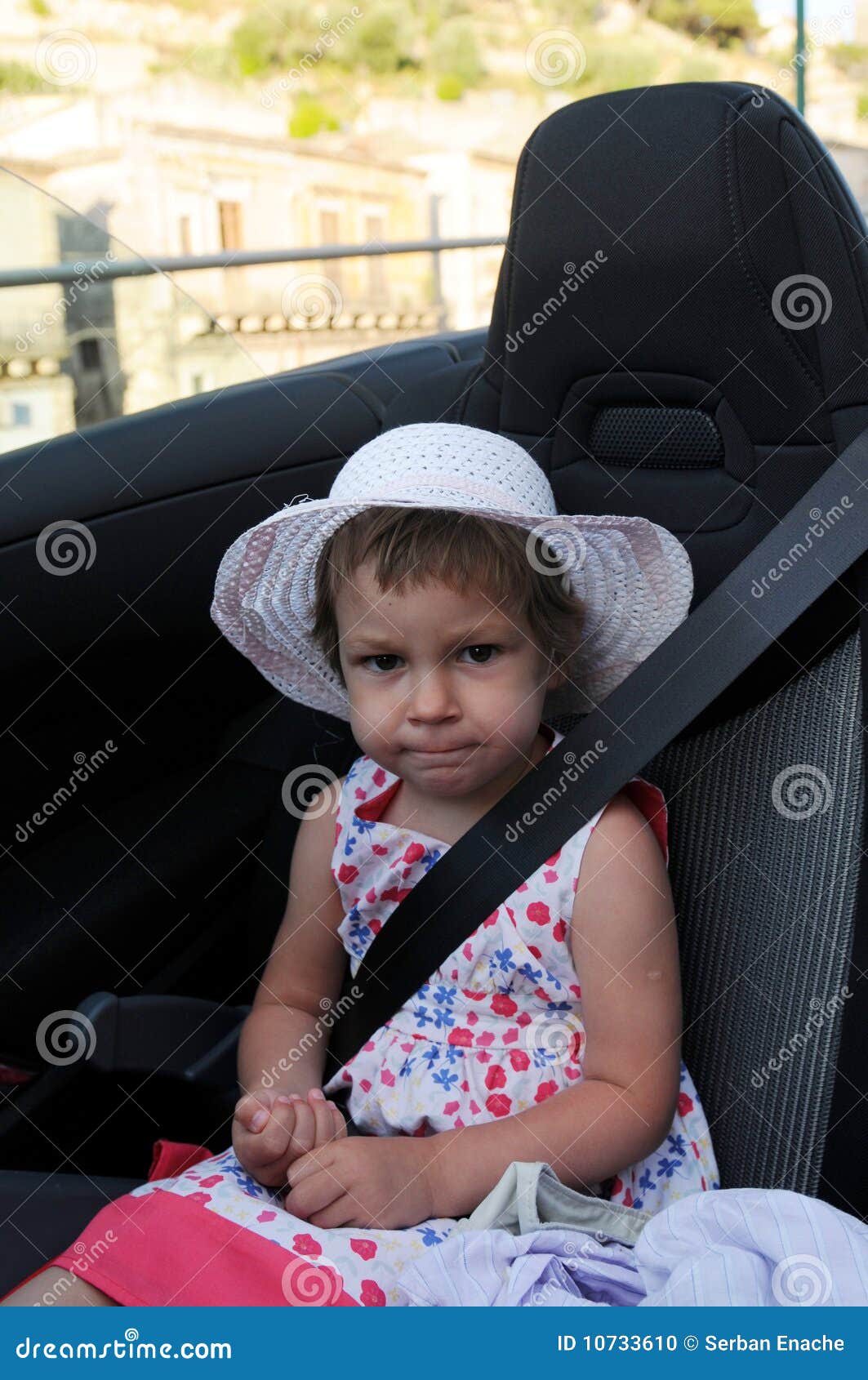bébé fille ceinturé dans une sécurité enfant voiture siège, sourit