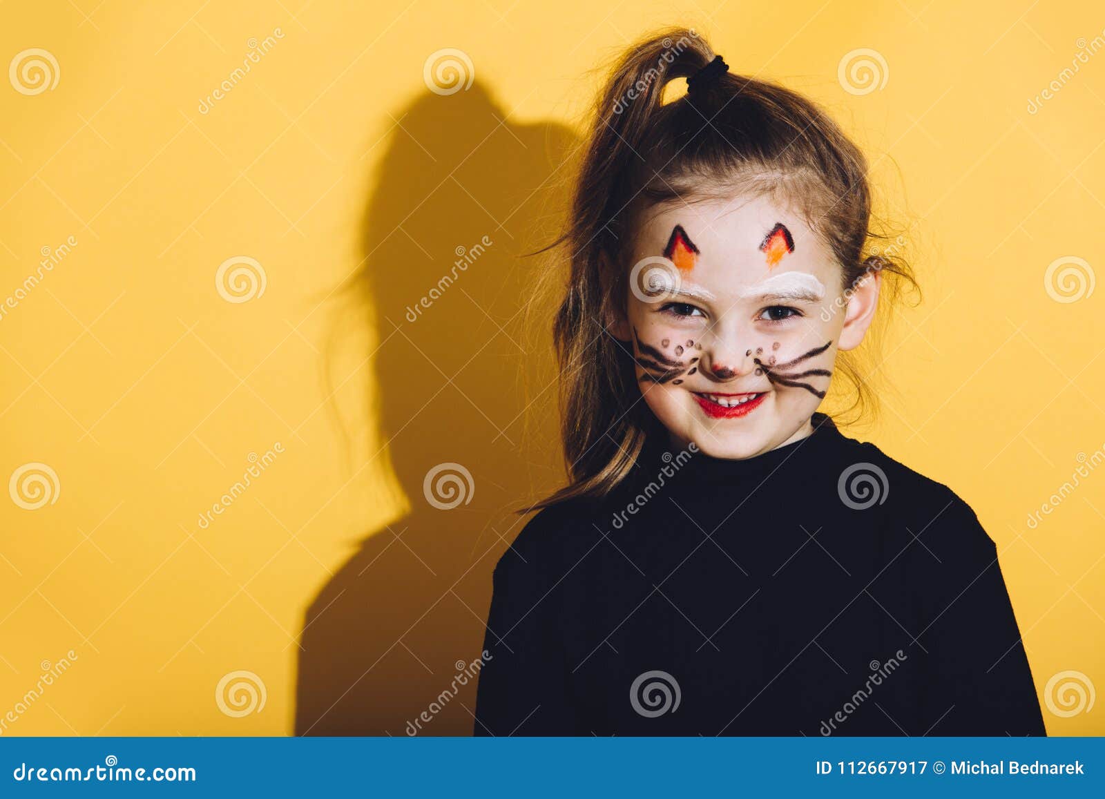 Petite Fille Avec Le Maquillage De Chat Sur Son Visage Image stock