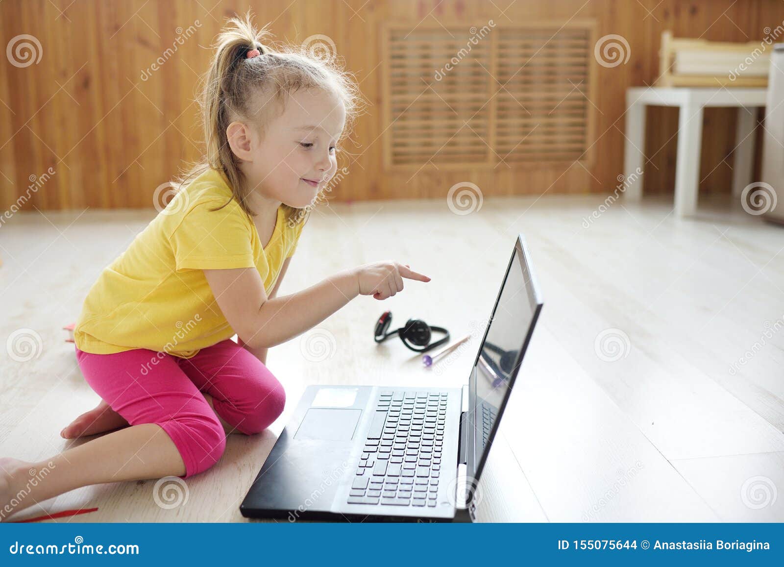 Petite Fille En Ligne Sur L'ordinateur Portable L'enfant Est Assis