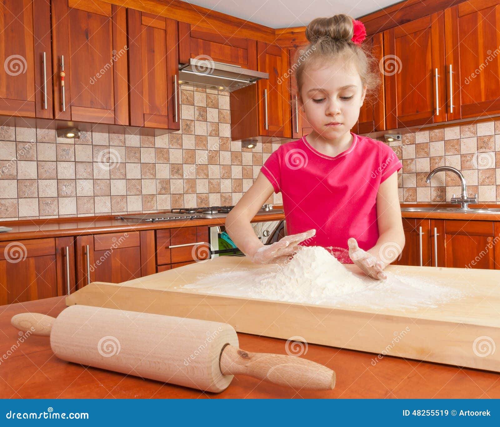 Petite fille jouant avec de la farine. Petite fille mignonne préparant la pâte dans la cuisine