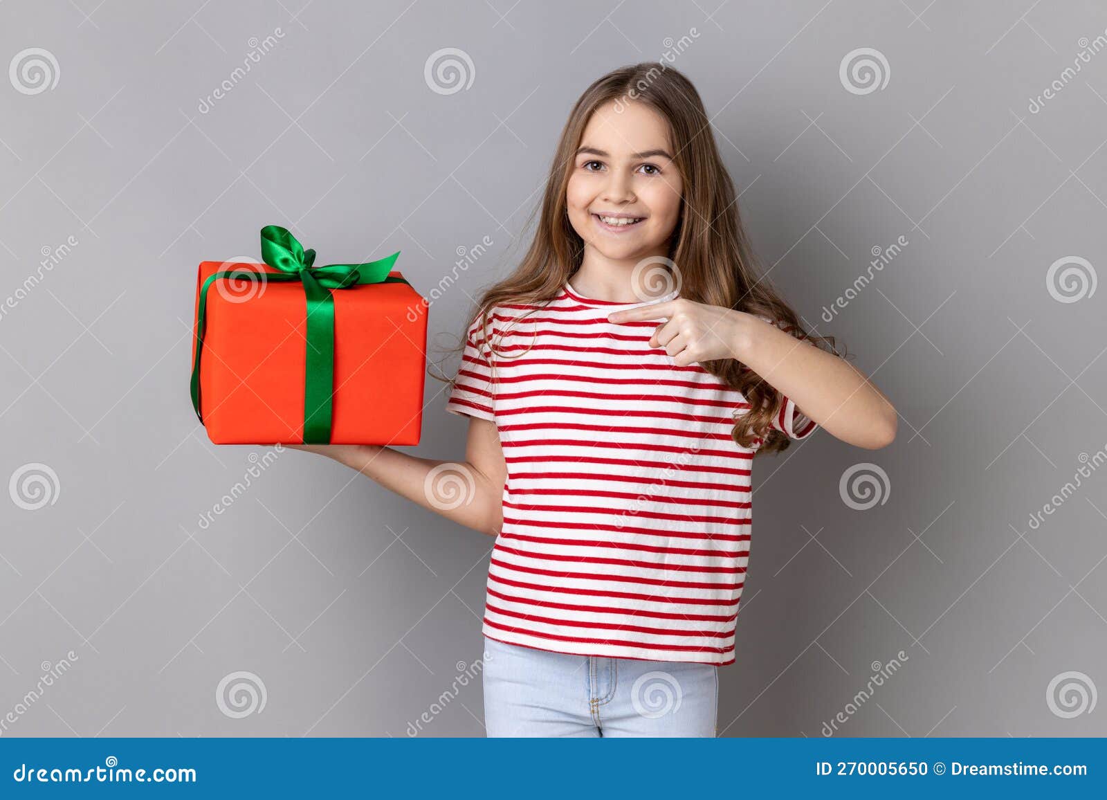 Petite Fille Pointant Vers La Boîte Cadeau Sourire à La Caméra Se Vantant  D'anniversaire Surprise. Photo stock - Image du amusement, fille: 270005650