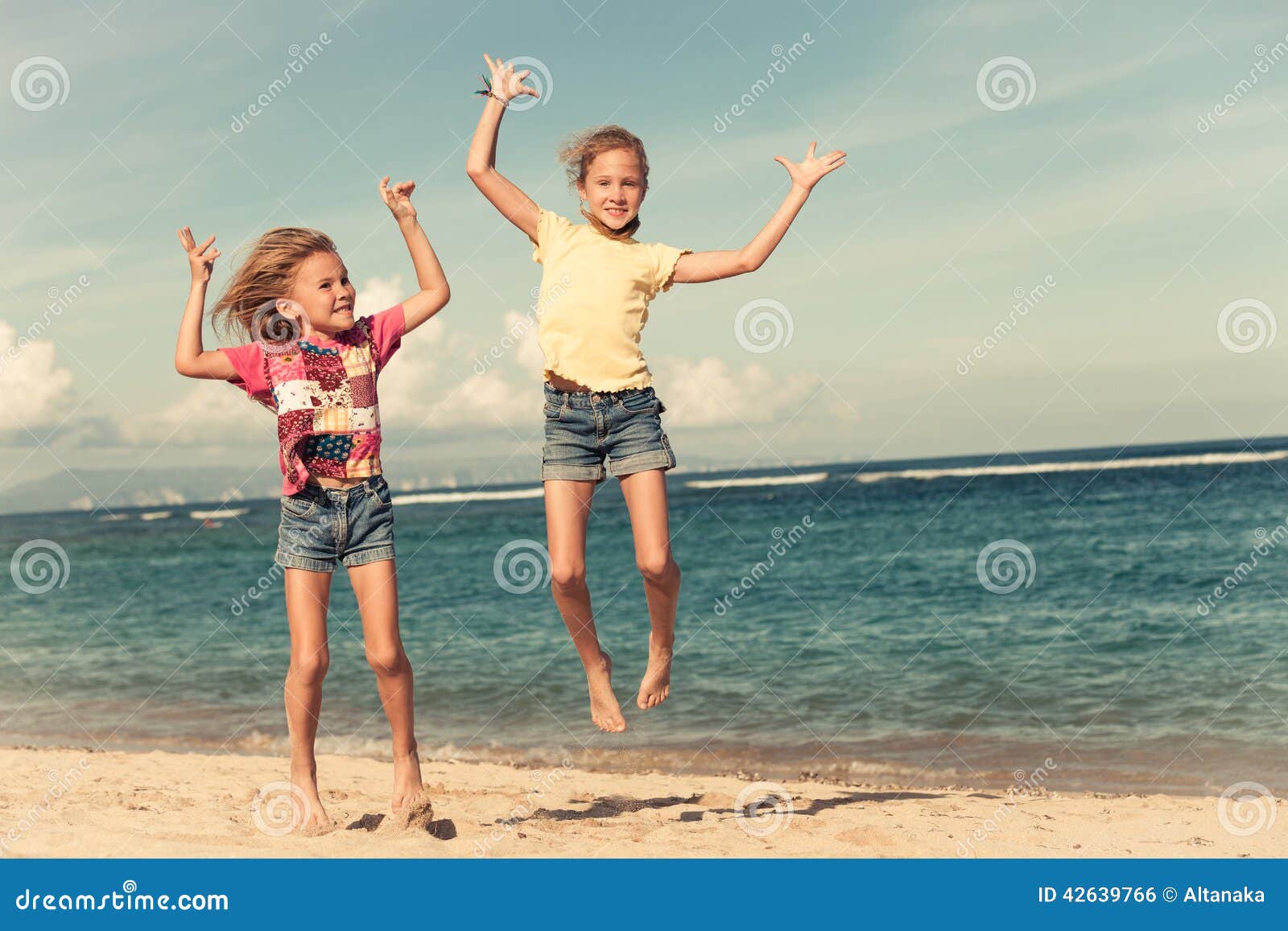 Petites Filles Heureuses Sautant Sur La Plage Photo stock Image du espiègle bonheur