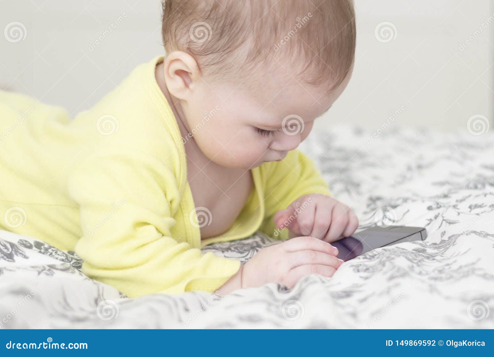 Peu Enfant Avec Un Telephone Portable Le Bebe 7 Mois Interesses Au Smartphone Se Trouve Sur Le Lit Et Pousse Un Doigt A L Ecran Photo Stock Image Du Mentalite Naif Peu Enfant Avec Un Telephone Portable Le Bebe 7 Mois Interesses Au Smartphone Se Trouve Sur Le Lit Et Pousse Un Doigt A L Ecran Photo Stock Image Du Mentalite Naif