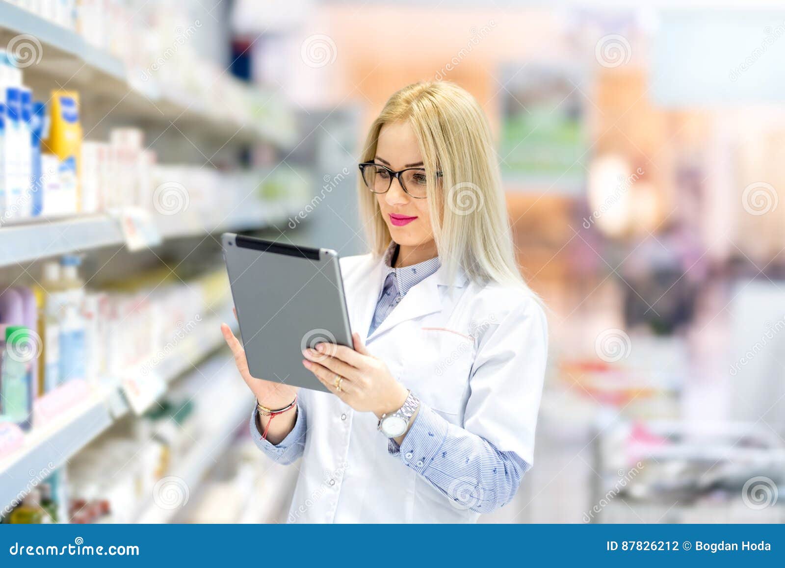 pharmacist chemist woman standing in pharmacy drugstore, smiling and using tablet
