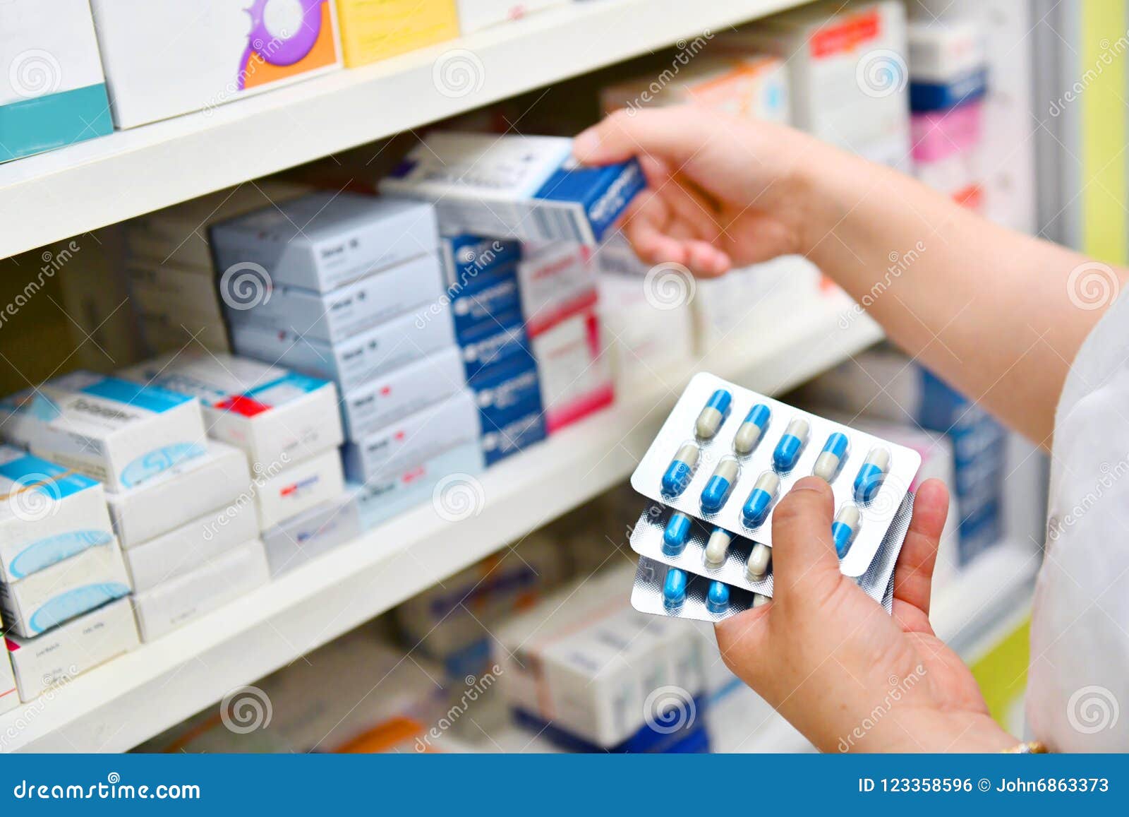 pharmacist holding medicine box and capsule pack