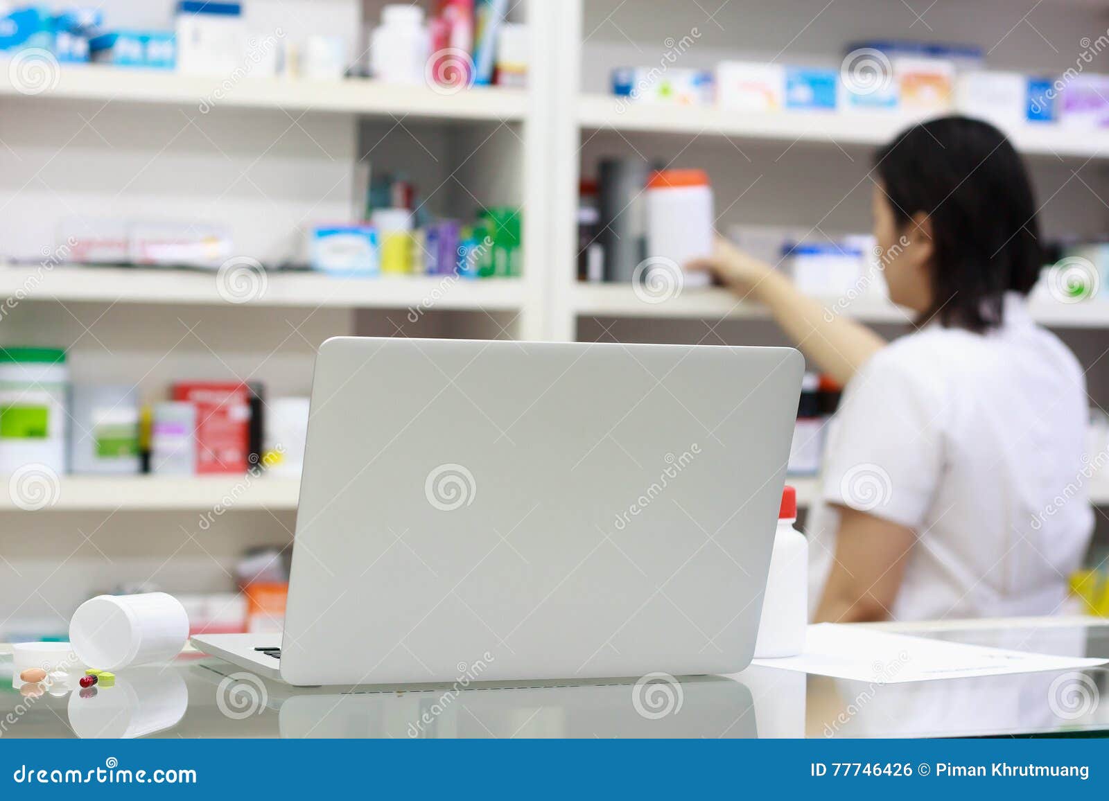 Pharmacist with Laptop Computer and Medication in the Pharmacy Stock