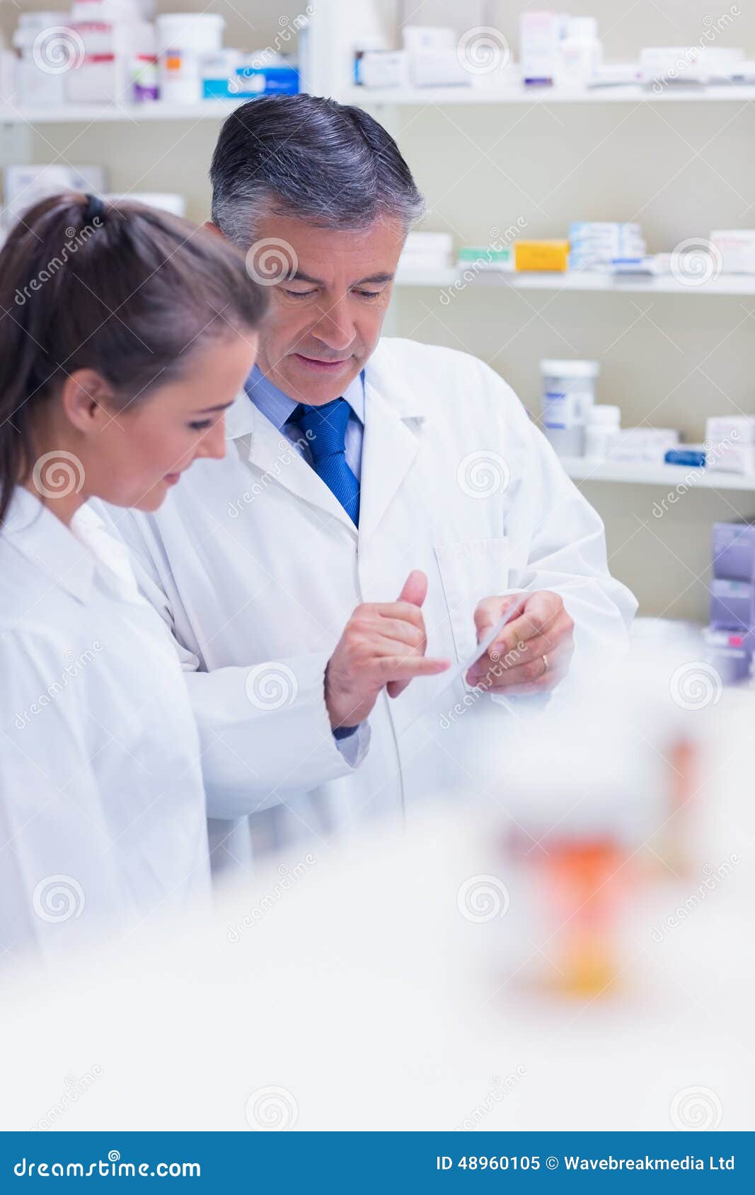 Pharmacist Speaking with His Trainee about Prescription Stock Image