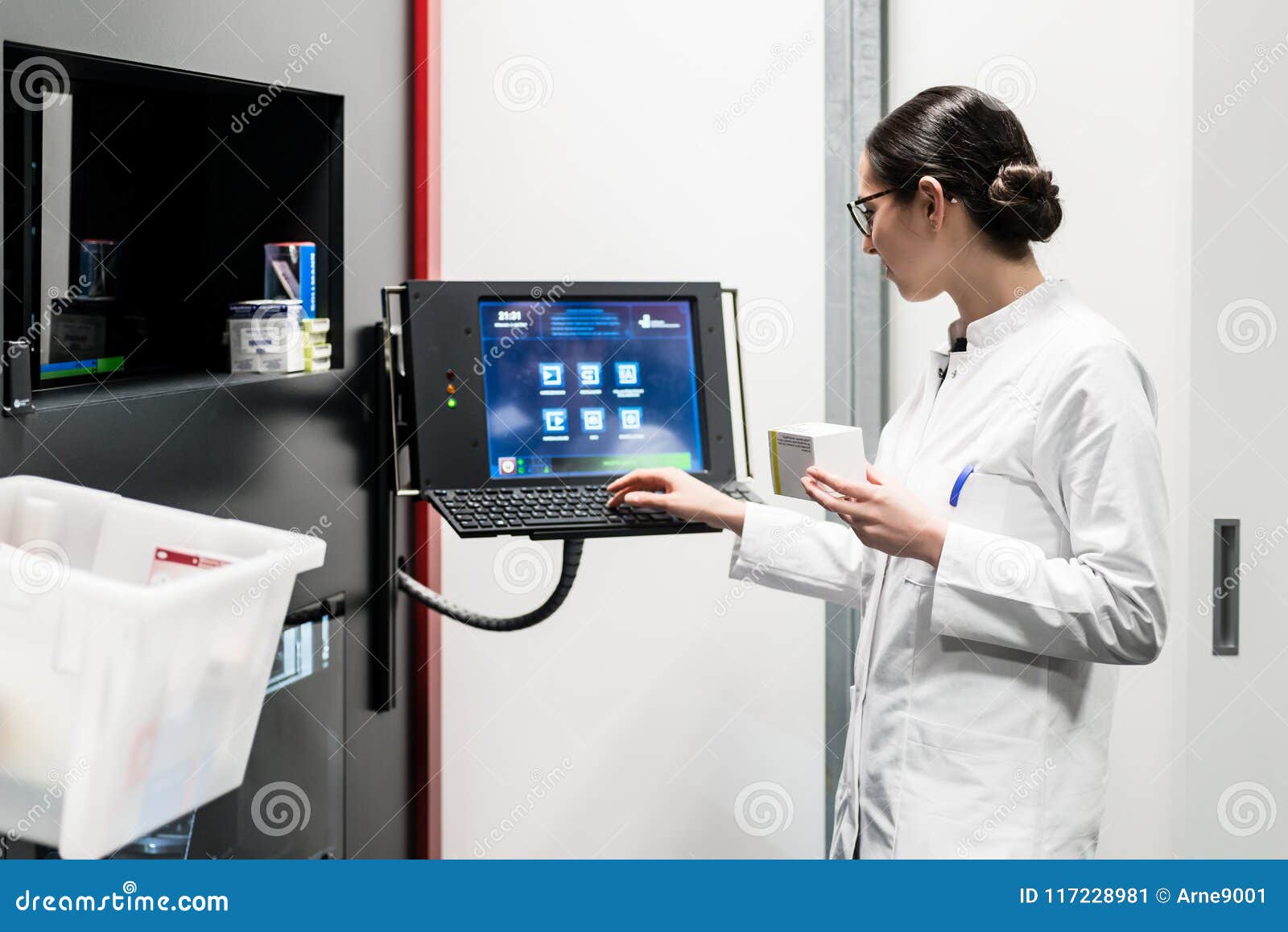 Pharmacist Using a Computer while Managing the Drug Stock Stock Image