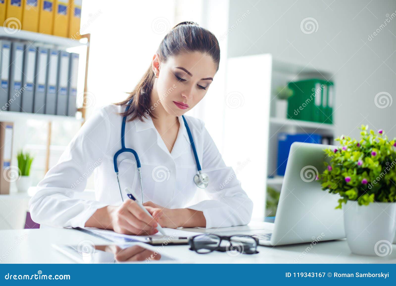 photo of attractive concentrated female doctor writing prescript