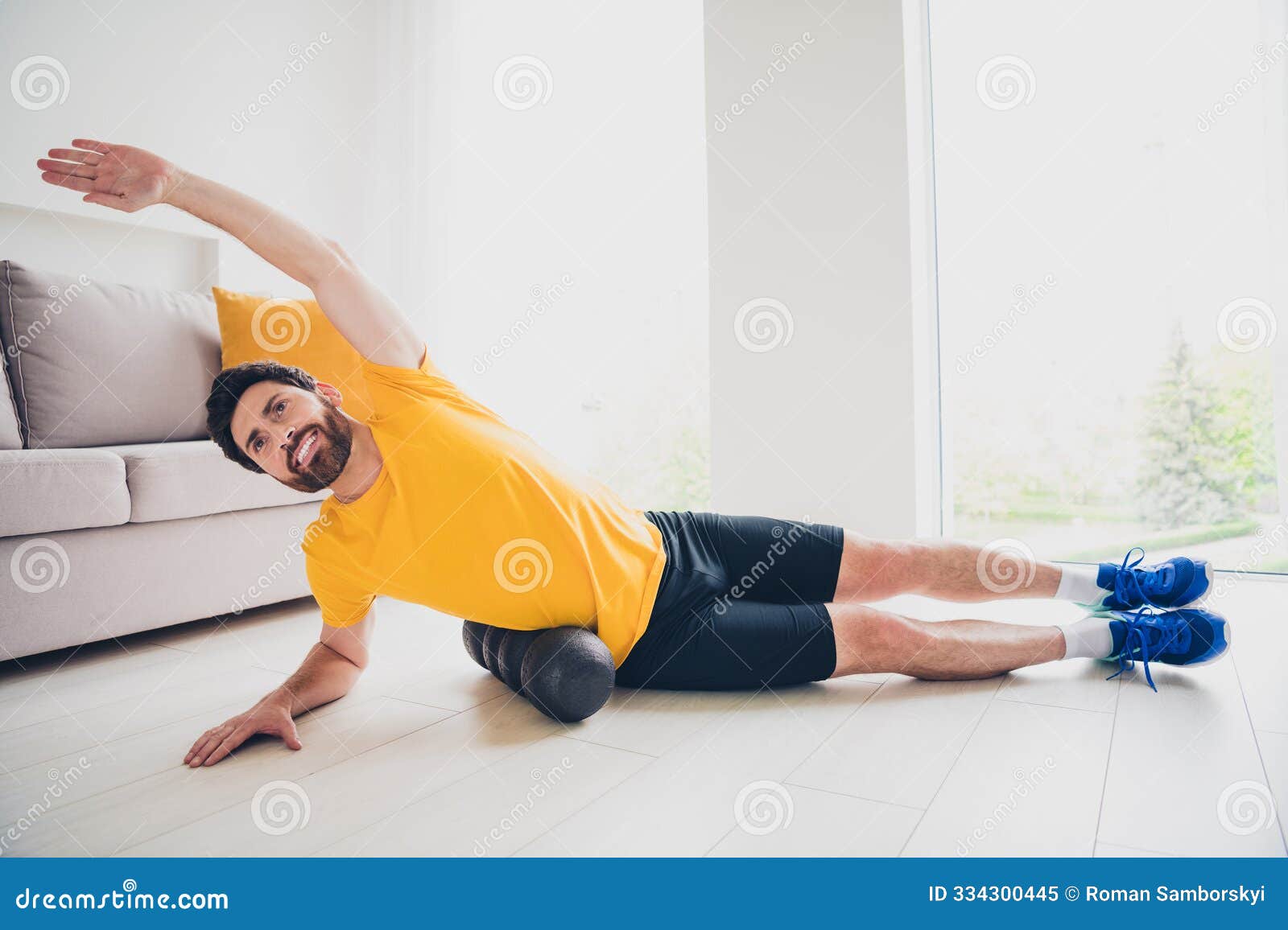 photo of attractive nice athletic man wearing sporty outfit lying mfr roll doing massage indoors house home gym