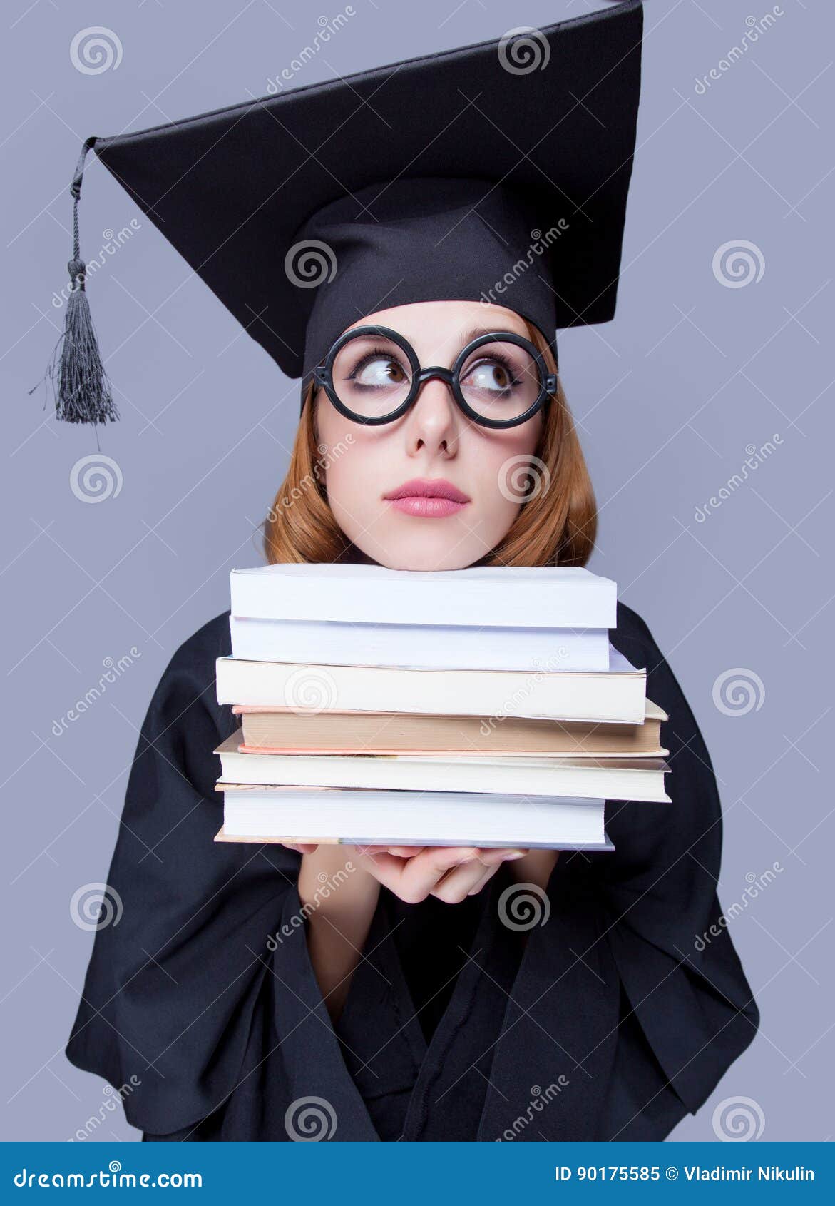 photo of beautiful young alumnus with pile of books on the wonderful grey studio background