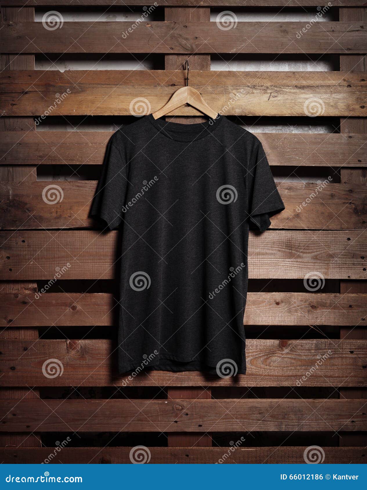 photo of black tshirt holding on wood background