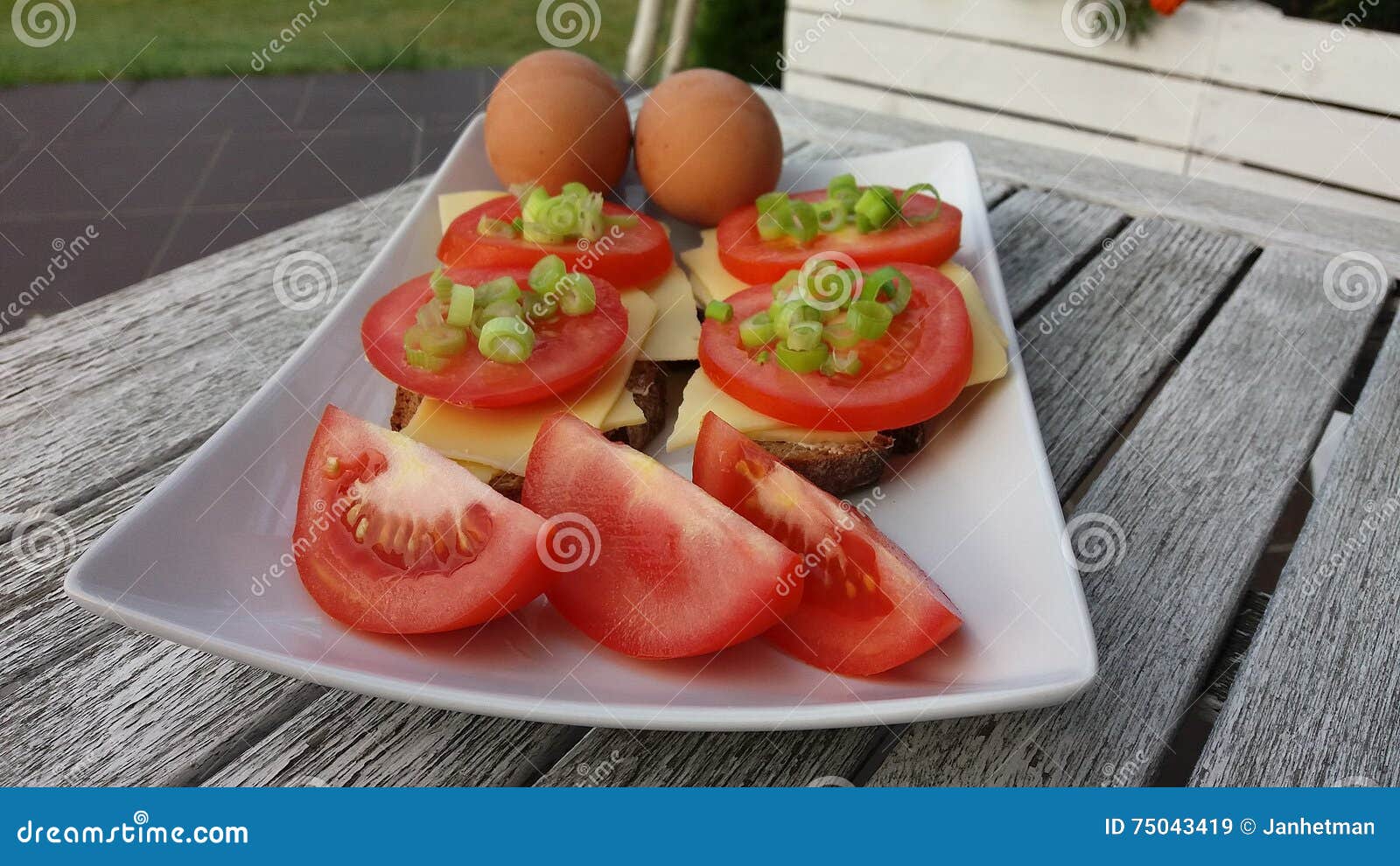 photo of breakfast: eggs and sandwiches with cheese and tomatoes