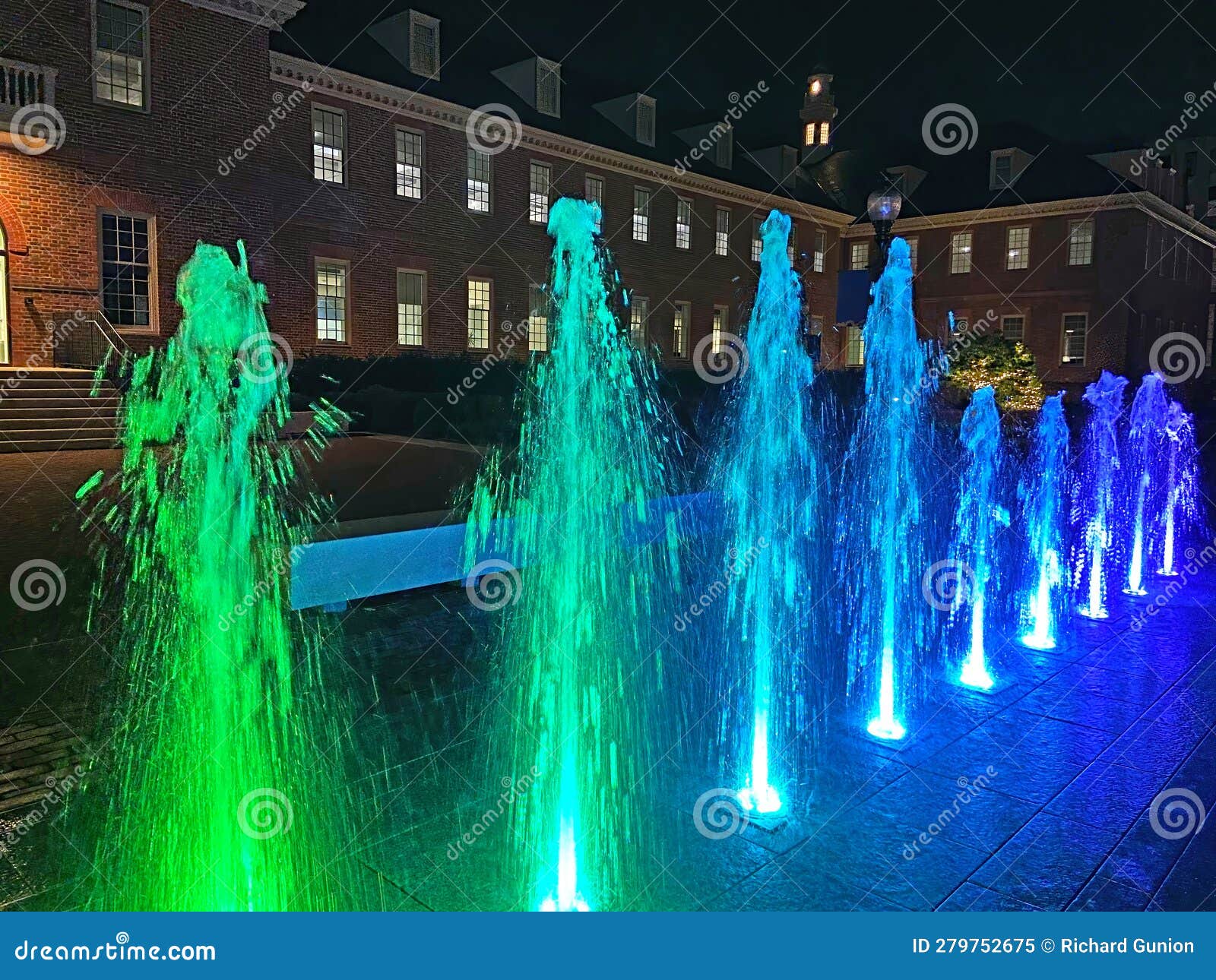 colorful water jets and old fannie mae building at night in washington dc