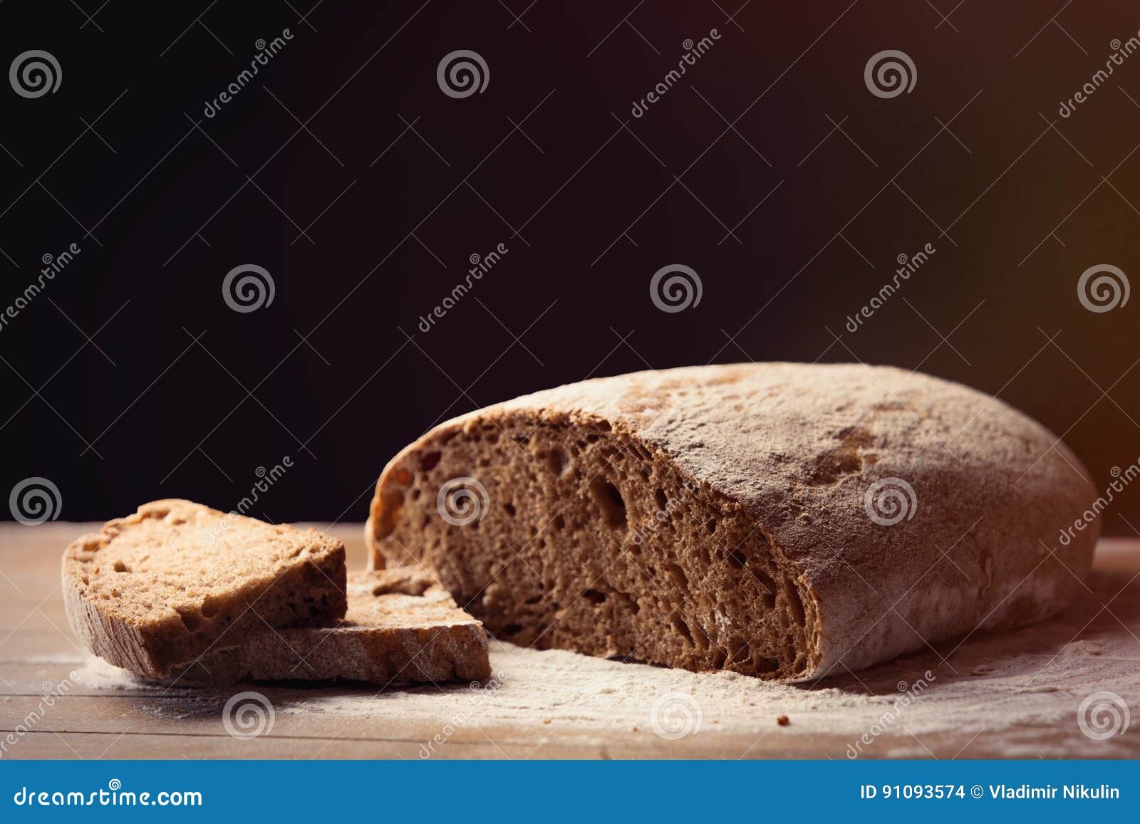 Photo de miche de pain fraîche savoureuse sur le fond en bois brun merveilleux