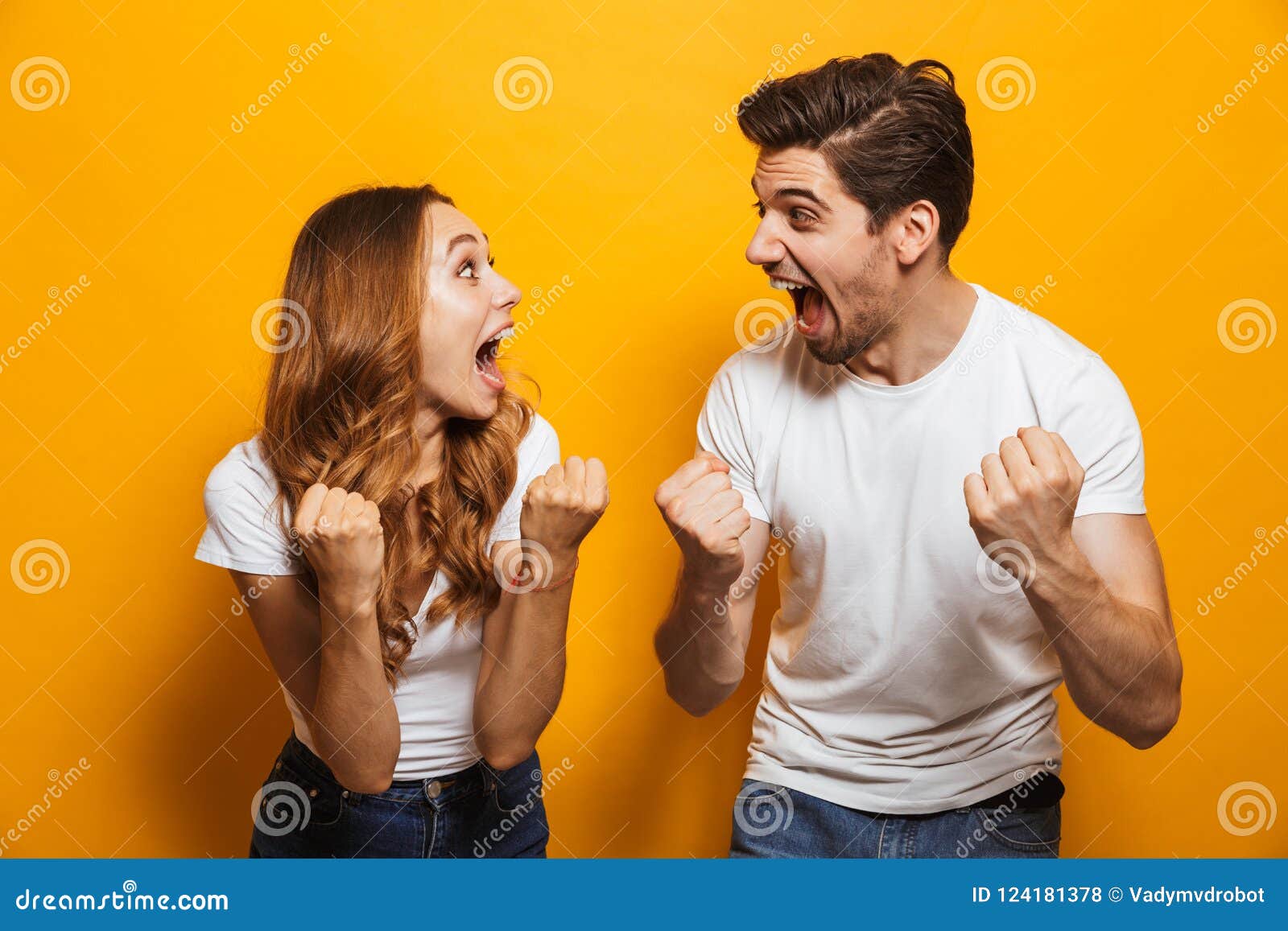 photo of delighted european man and woman in basic clothing screaming and clenching fists like winners or happy people, 