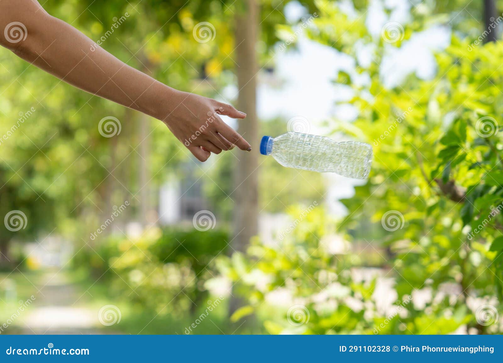 Photo of Hands Throwing Away Plastic Bottles in Nature Stock Photo