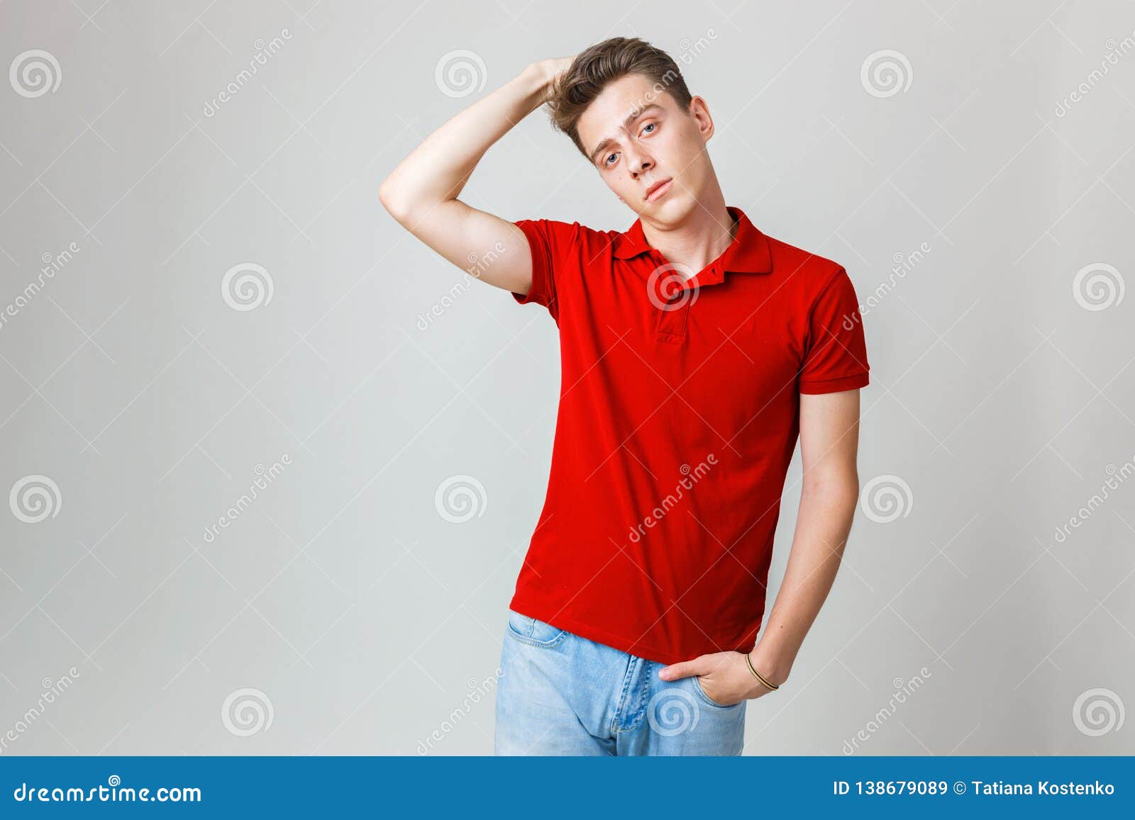 Photo of Handsome Guy Wearing Red Shirt and Blue Smiling Standing Over White with Boring Facial Stock Image Image of adult, portrait: 138679089