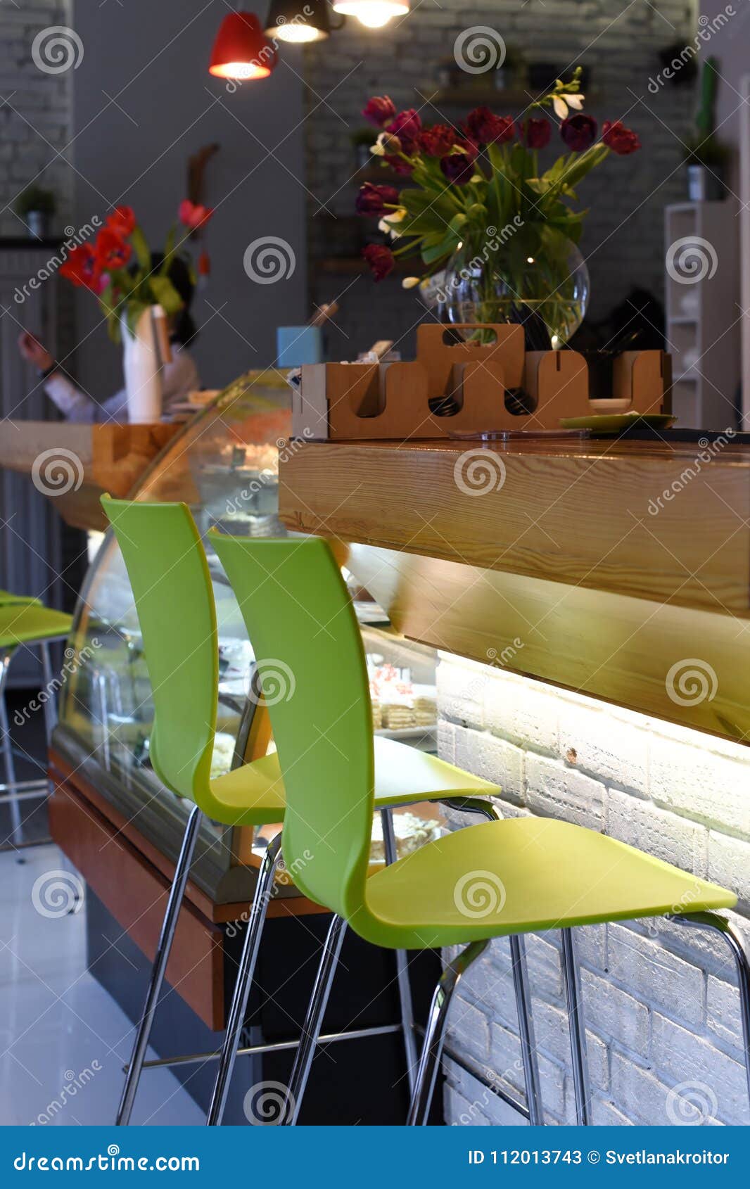 a photo of an interior of a cozy modern urban cafe with low warm light and noone inside