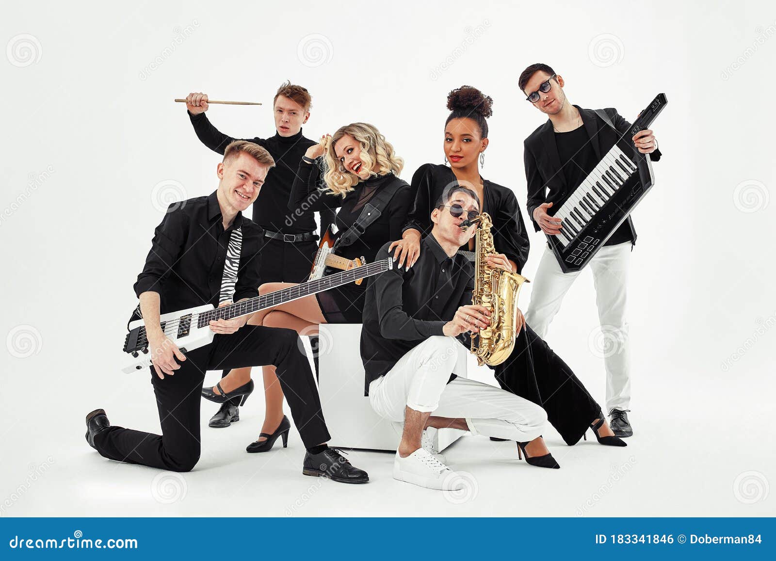 photo of multi ethnic music band in studio.musicians and woman soloist posing over white background