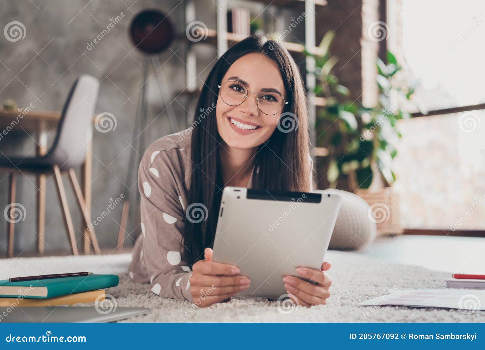 photo of nice optimistic girl lying write tablet wear spectacles pijama at home