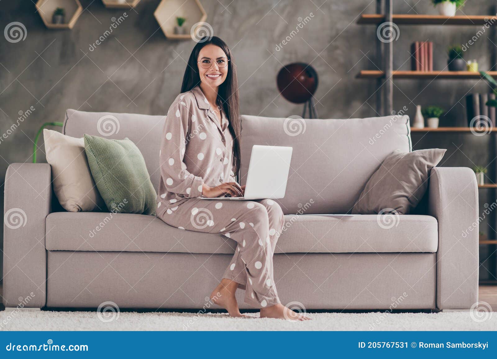 photo of nice optimistic girl sit write laptop wear spectacles pijama at home on sofa
