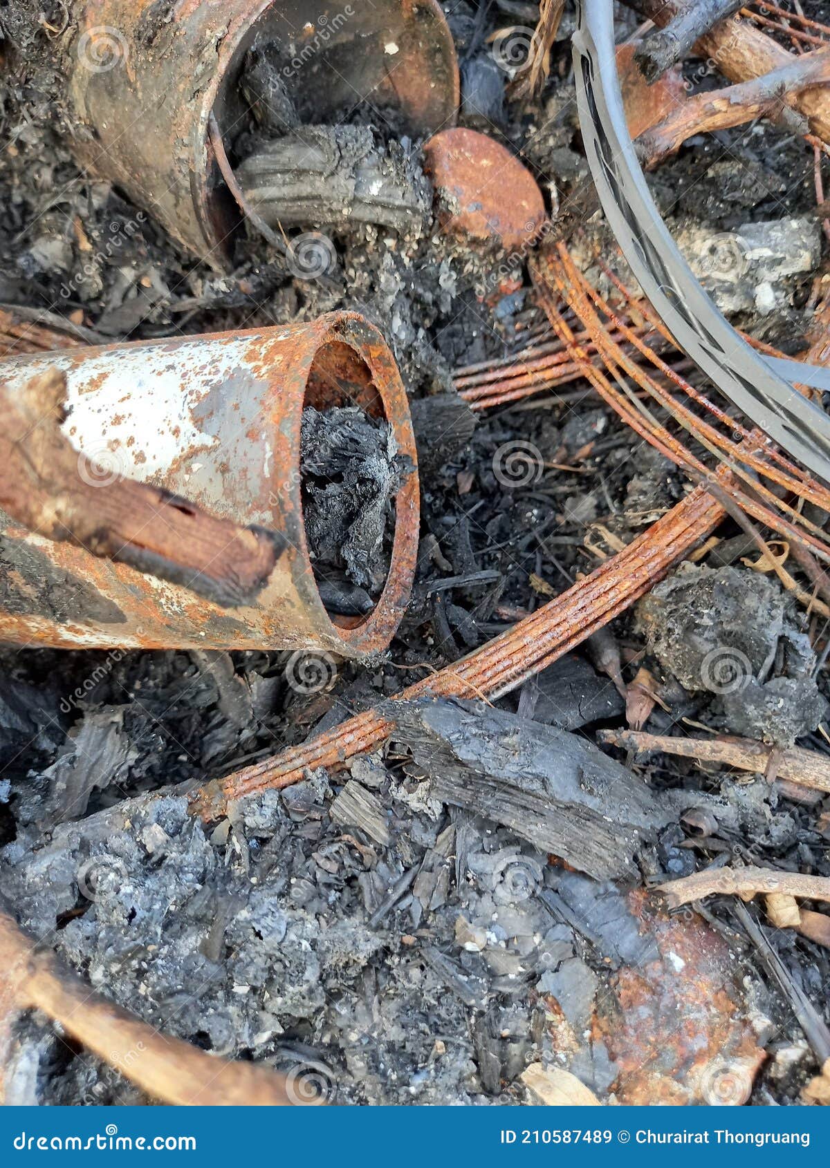 a photo of a pile of waste that traces its burning and over time rusts objects