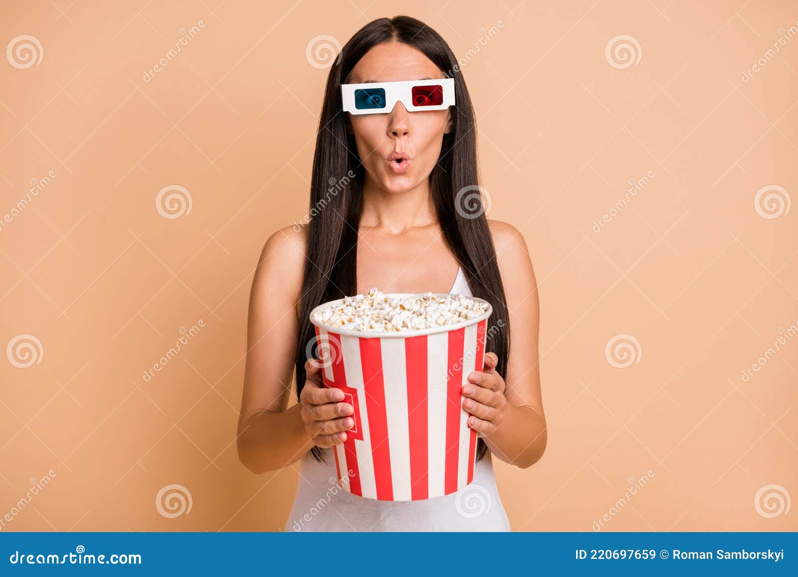 Woman with big thighs holding a larg bag of popcorn Stock Photo