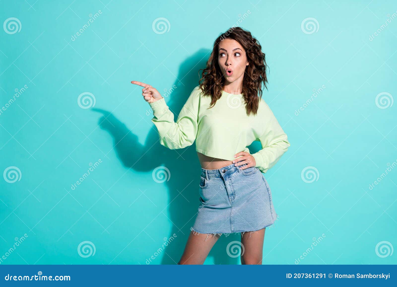 Photo Portrait Of Curly Pretty Brunette Pointing With Finger Looking At
