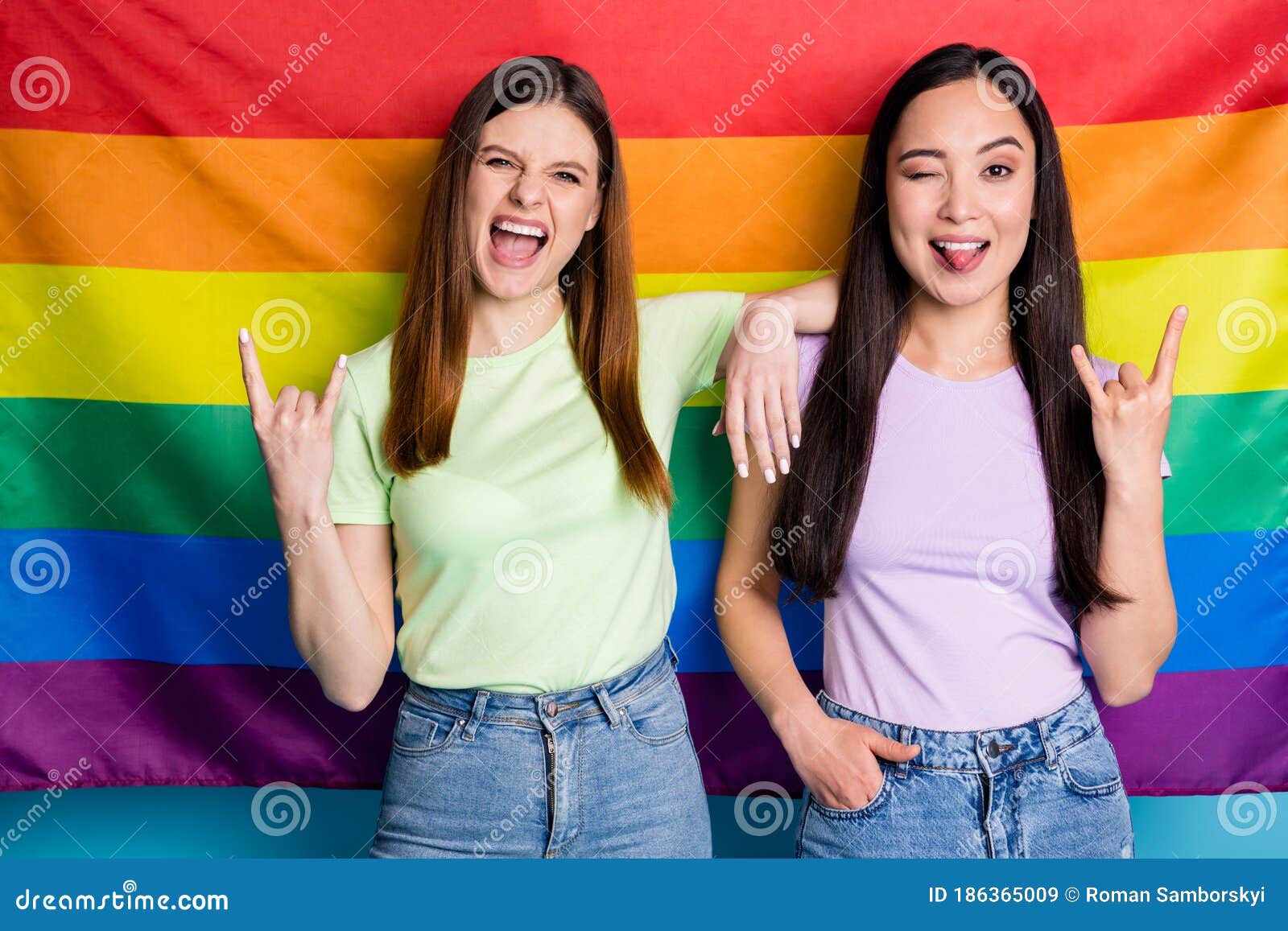 Photo of Pretty Crazy Lesbians Couple Ladies Parade Day Support Same Sex Marriage Showing Horns Tongue Stand in Front of Stock Image pic