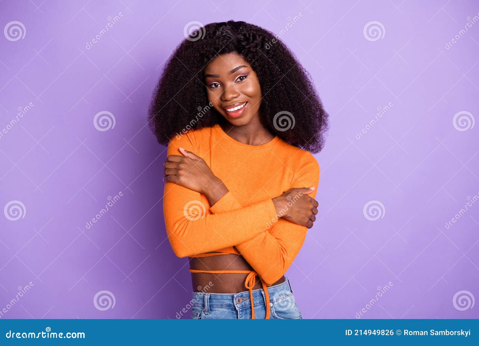 photo of shiny sweet dark skin lady wear orange shirt embracing herself  violet color background