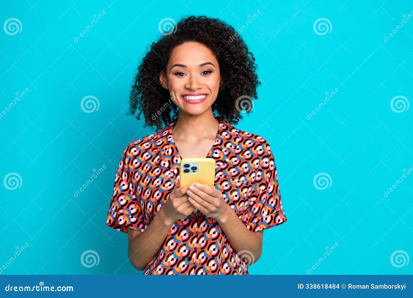 photo of toothy beaming woman with perming coiffure dressed stylish blouse holding smartphone in hands  on blue