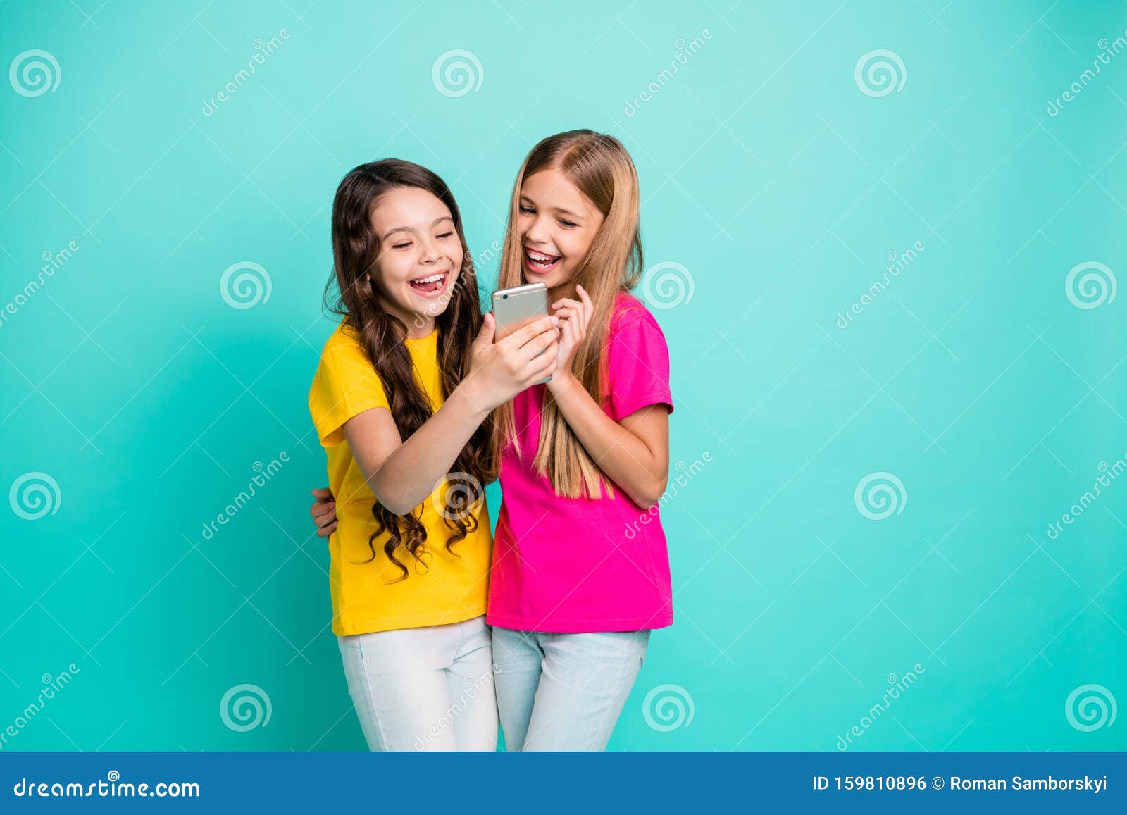 Photo of Two Encouraged Funny Nice Cute Girls People Wearing T-shirts Pink  Yellow Watching Some Video on Telephone while Stock Photo - Image of girl,  model: 159810896