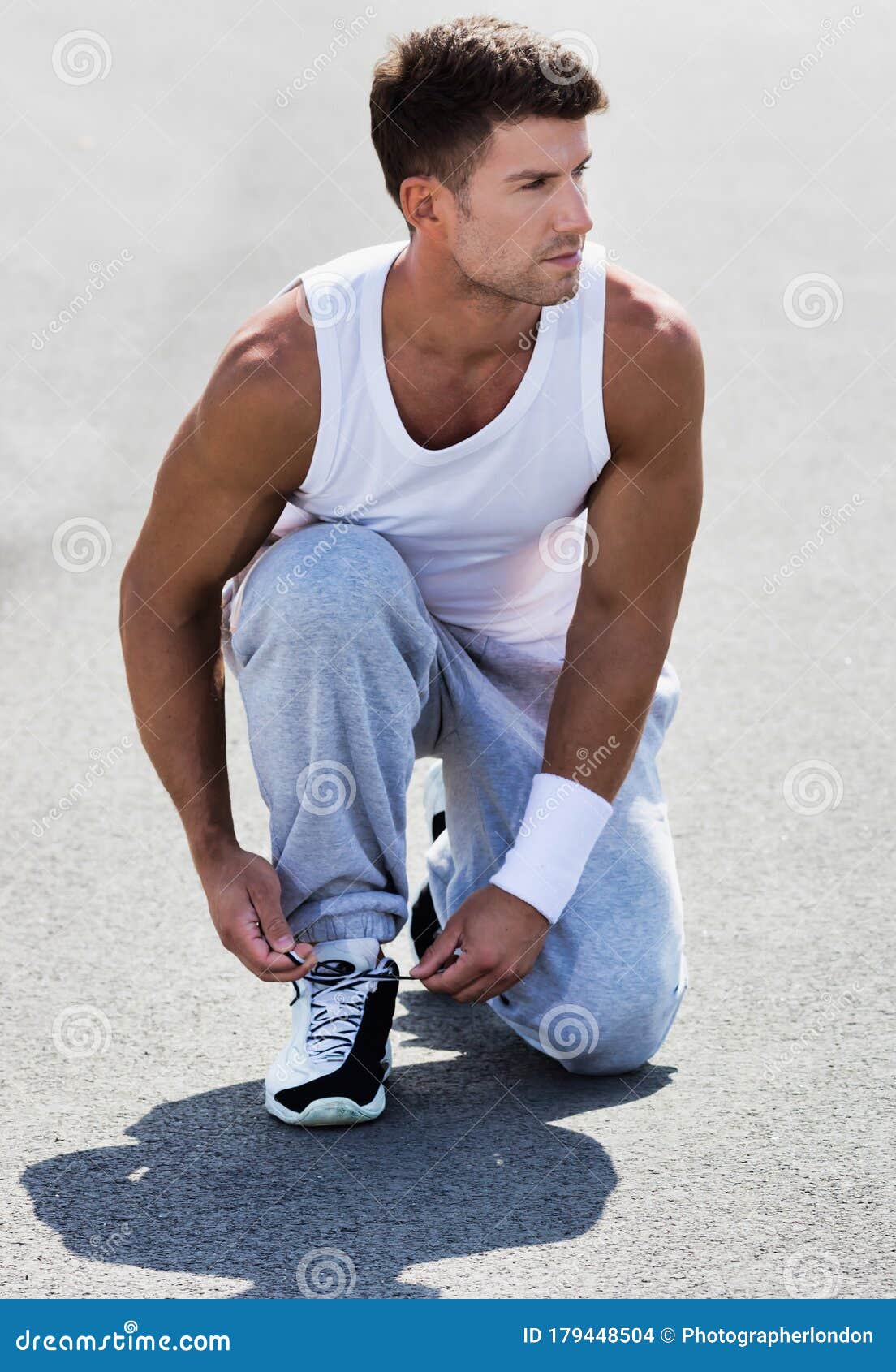 Portrait of Young Attractive Man Wearing Sports Wear Tying His Rubber ...