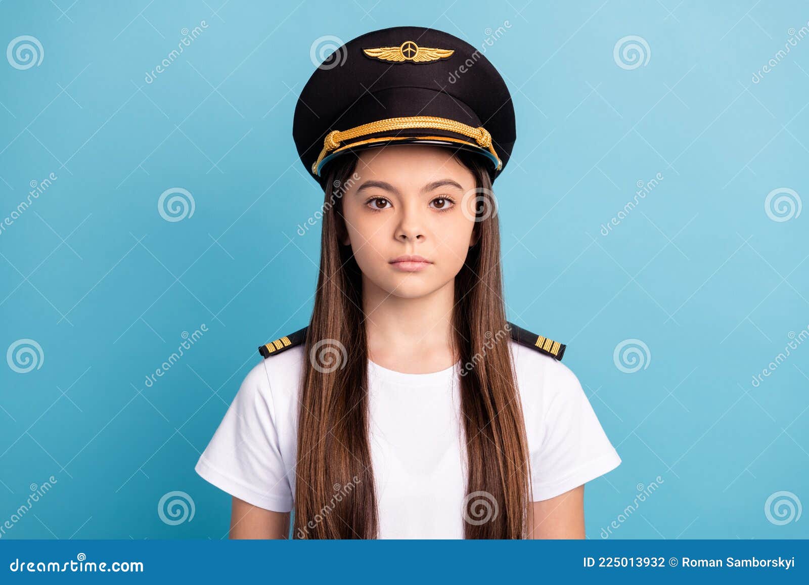 Photo of Young Serious Good Looking Little Girl in Pilot Cap and White  T-shirt with Long Brunette Hair on Blue Stock Photo - Image of captain,  headshot: 225013932