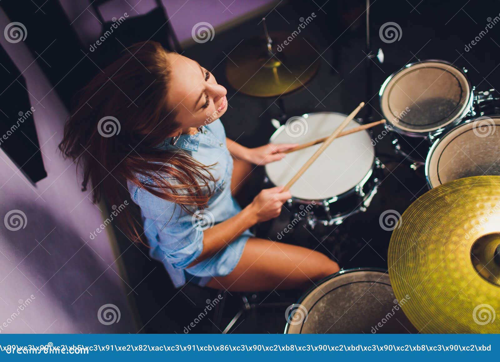 Photograph Of A Female Drummer Playing A Drum Set On Stage. Stock Image