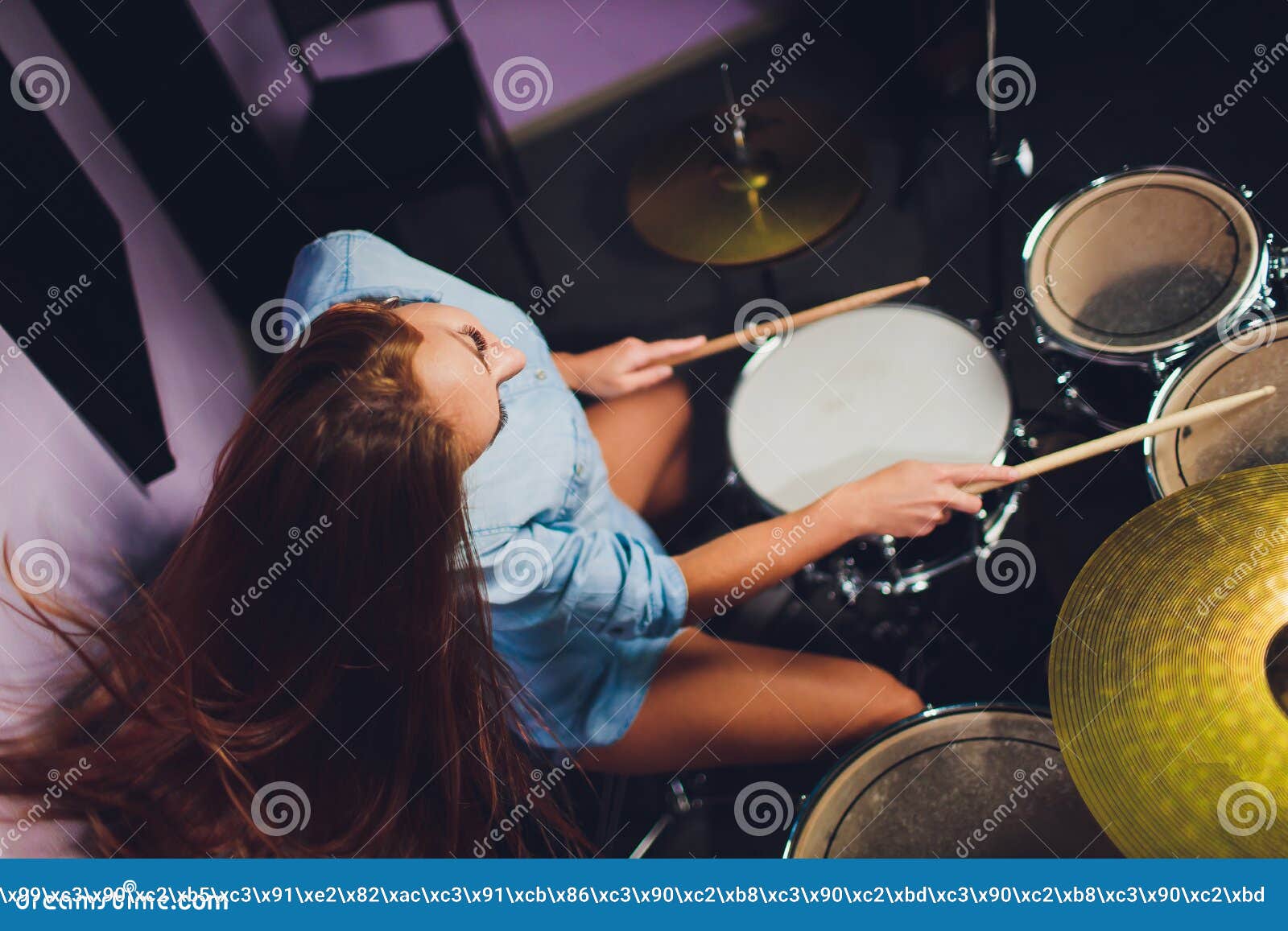 Photograph of a Female Drummer Playing a Drum Set on Stage. Stock Image