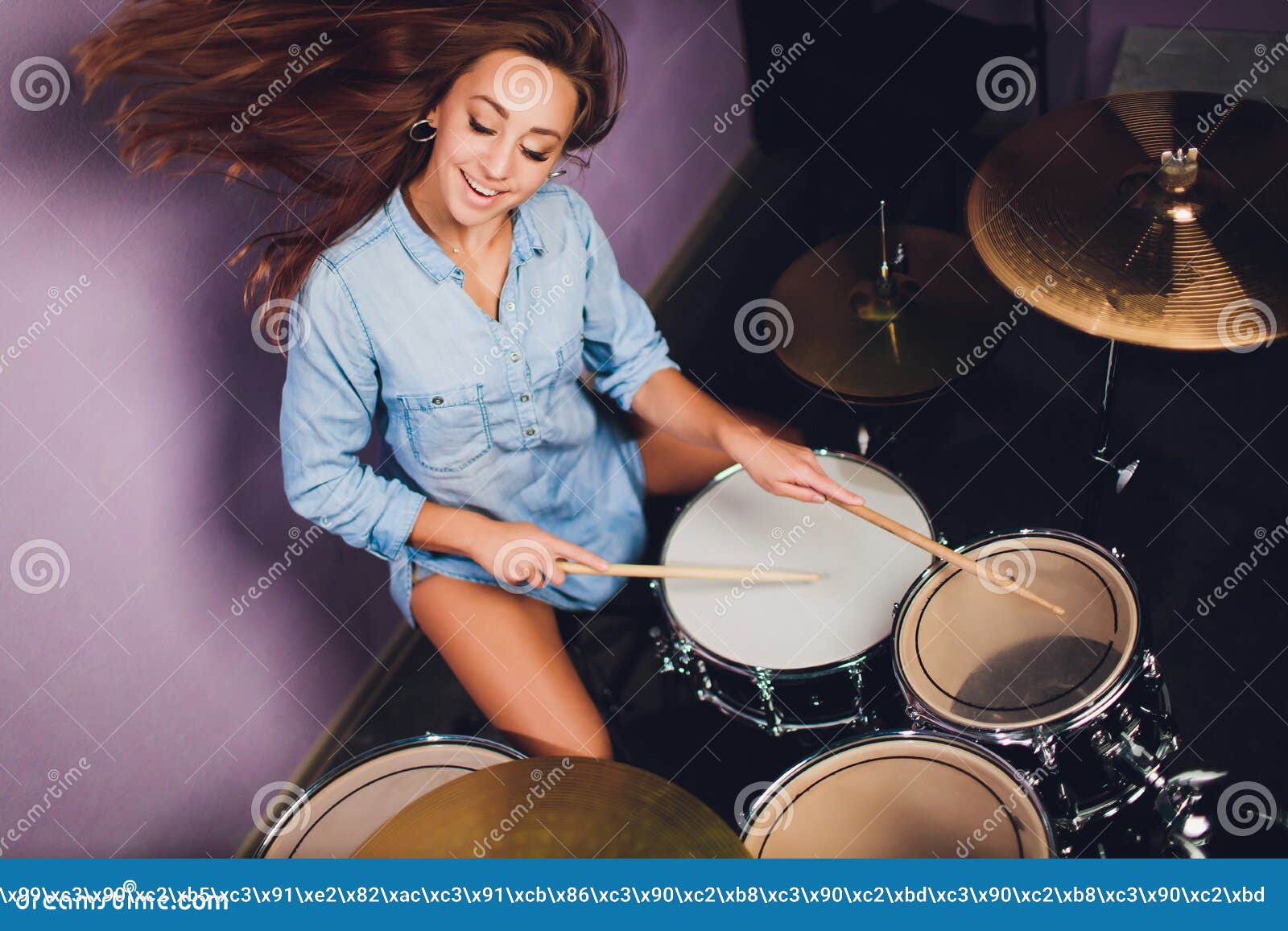 Photograph of a Female Drummer Playing a Drum Set on Stage. Stock Image