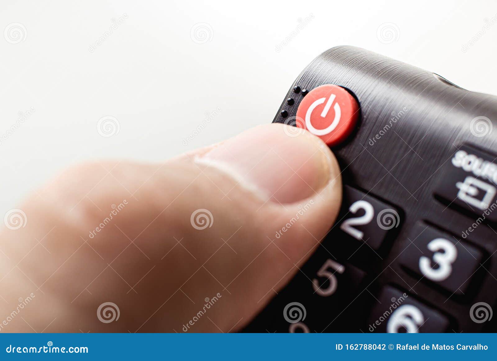 photograph of a hand holding a television remote control