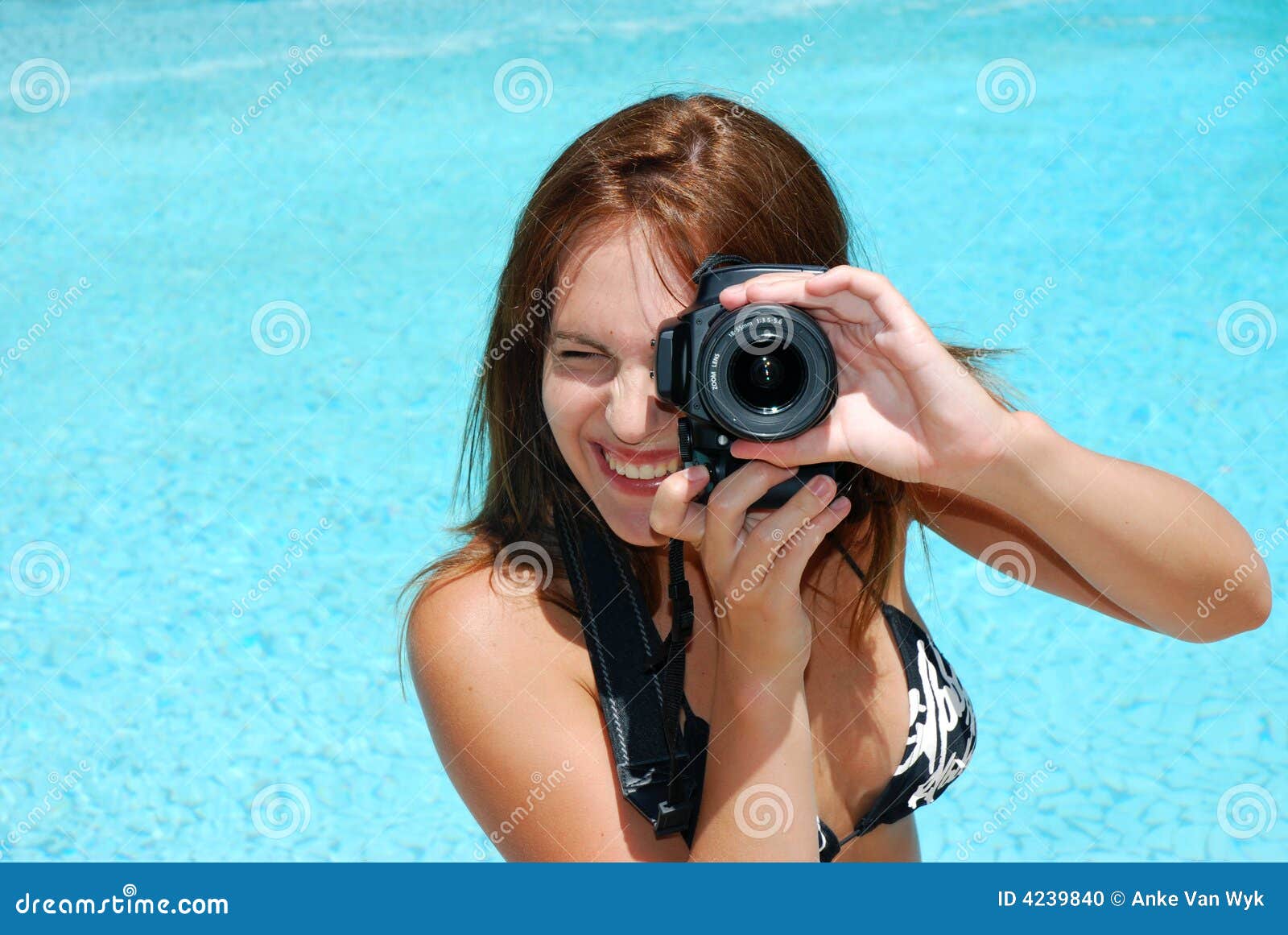 Photographe féminin. Un beau photographe blanc caucasien de jeune femme utilisant un bikini et prenant des photos à l'extérieur