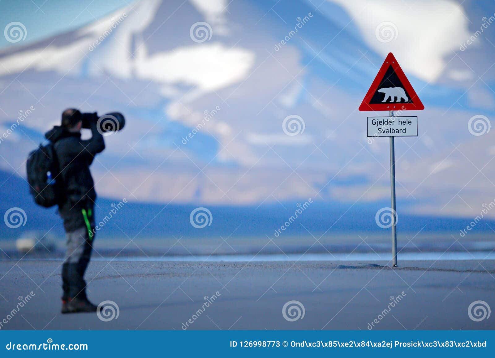 photographer with big lens and road traffic sign with polar bear. Ã¯Â¿Â½gjelder hele svalbard means over all of svalbard watch out f