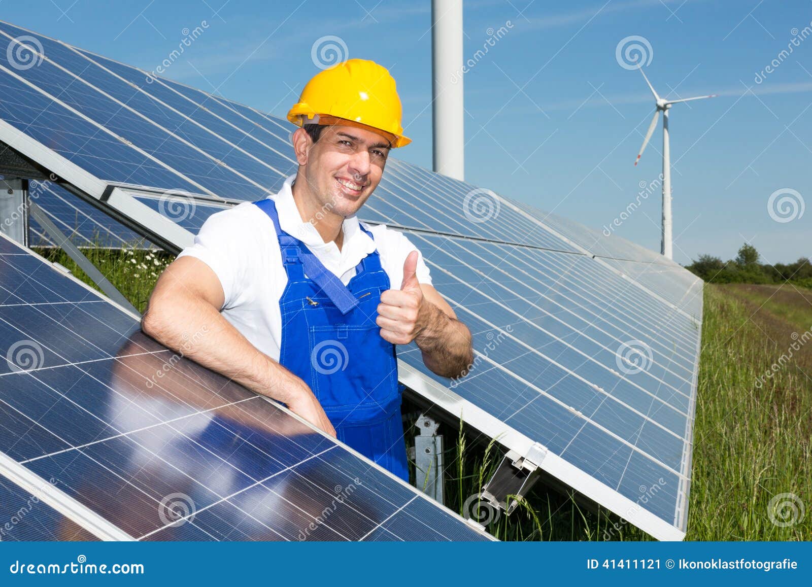 Photovoltaic engineer showing thumbs up at solar energy array