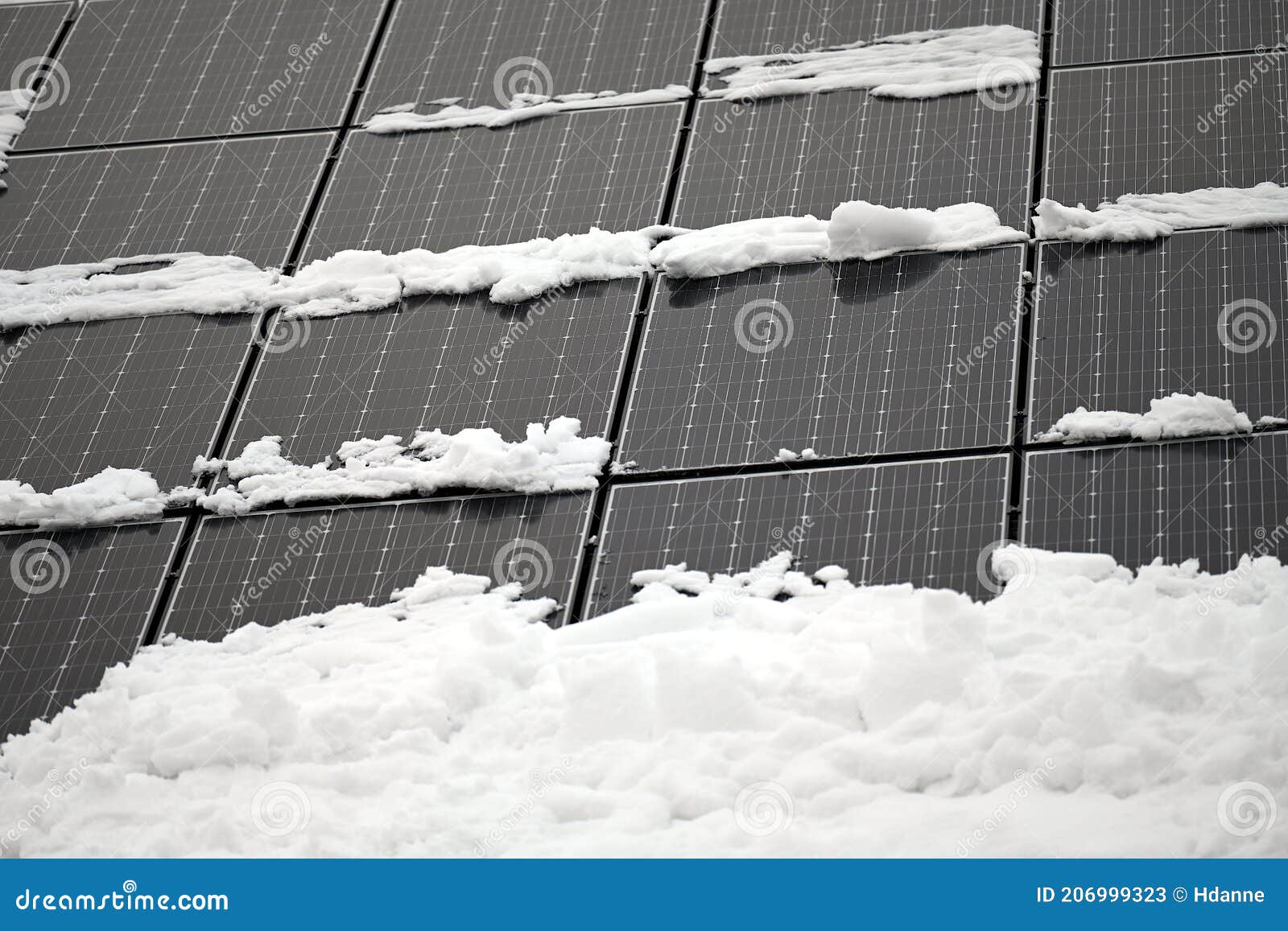 photovoltaic solar panels on a roof partly covered with snow [