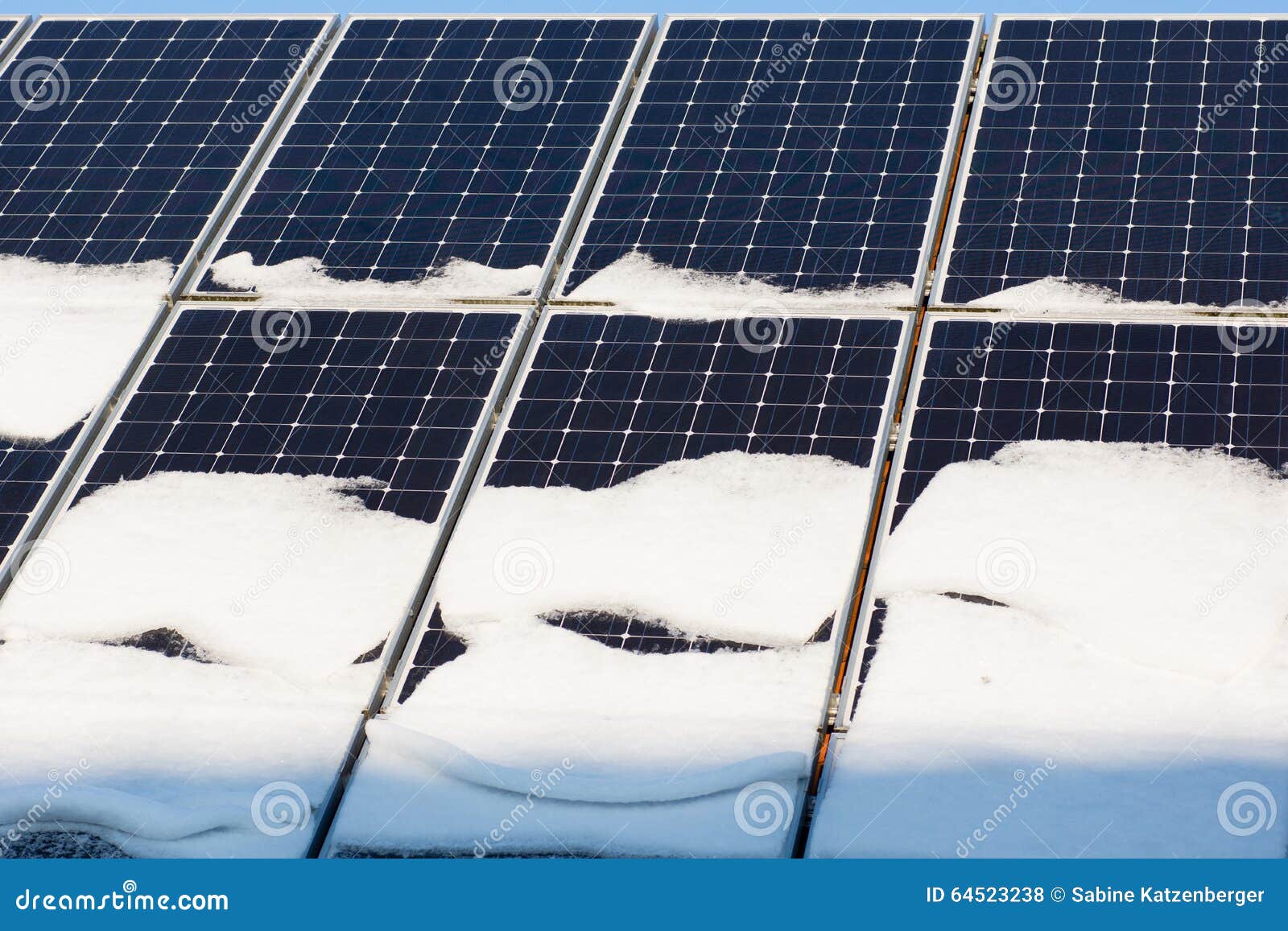 Photovoltaic panels on the roof with snow, with a snow shovel in