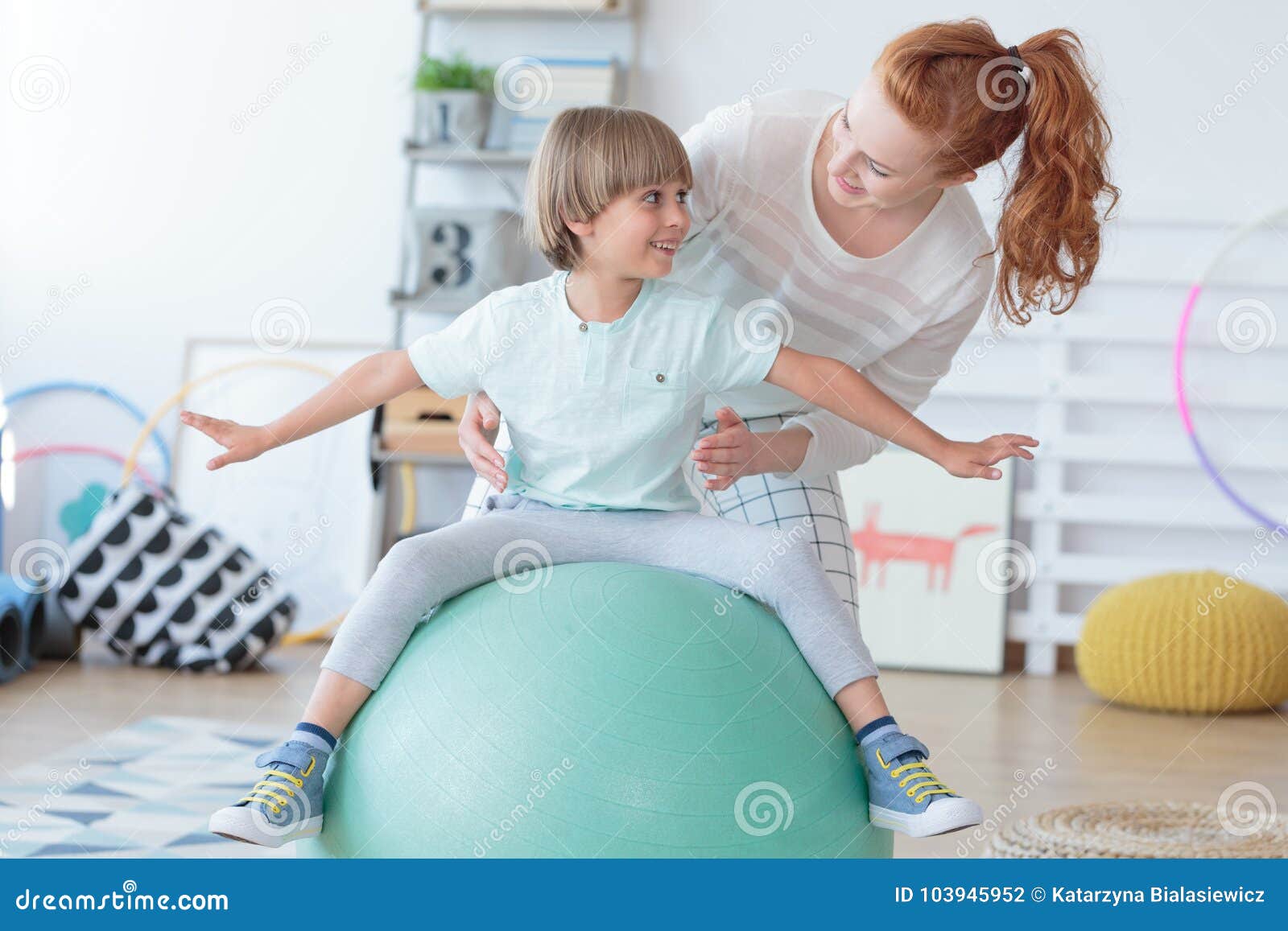 physical therapist assisting little boy