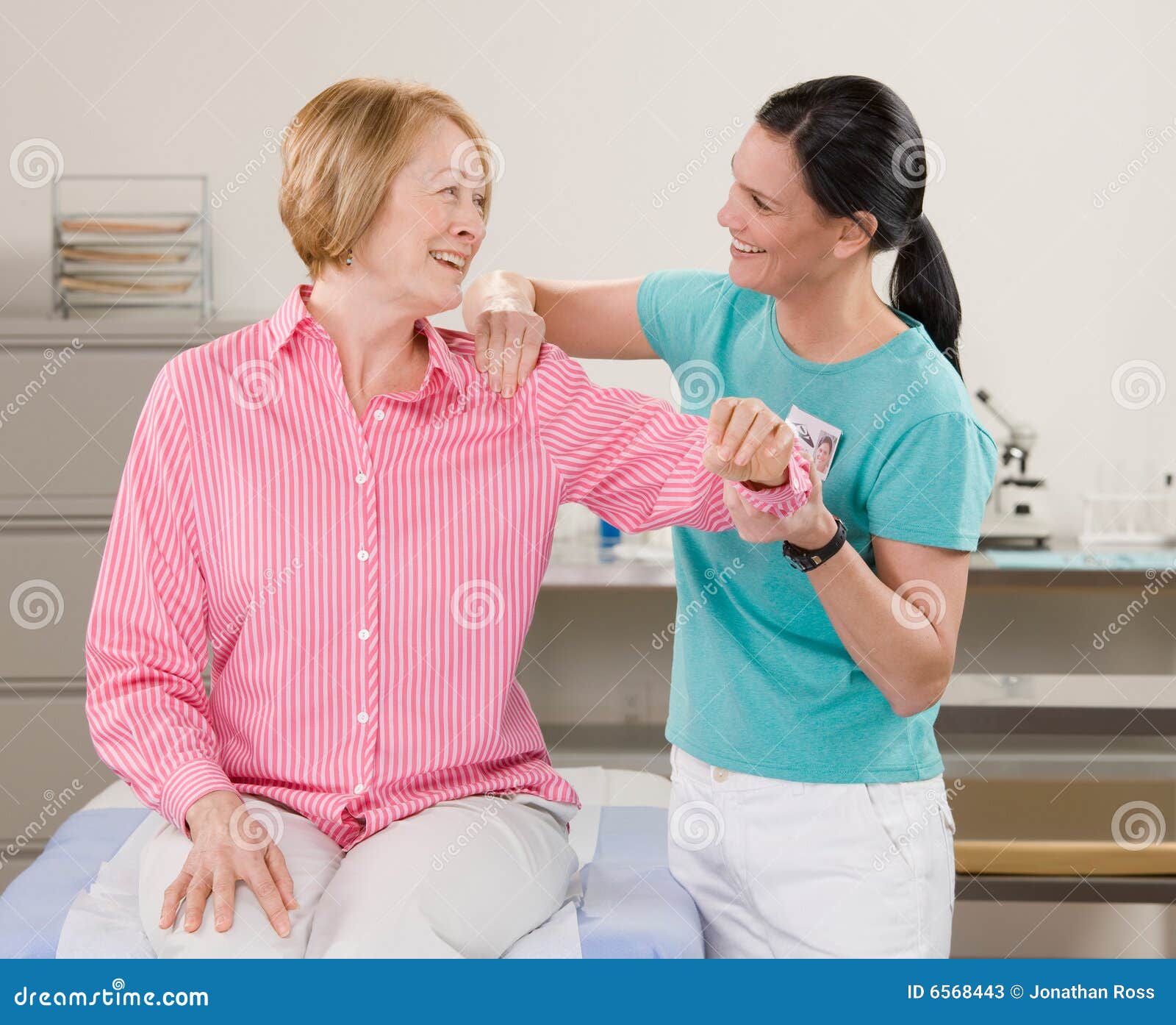 physical therapist checking womans shoulder