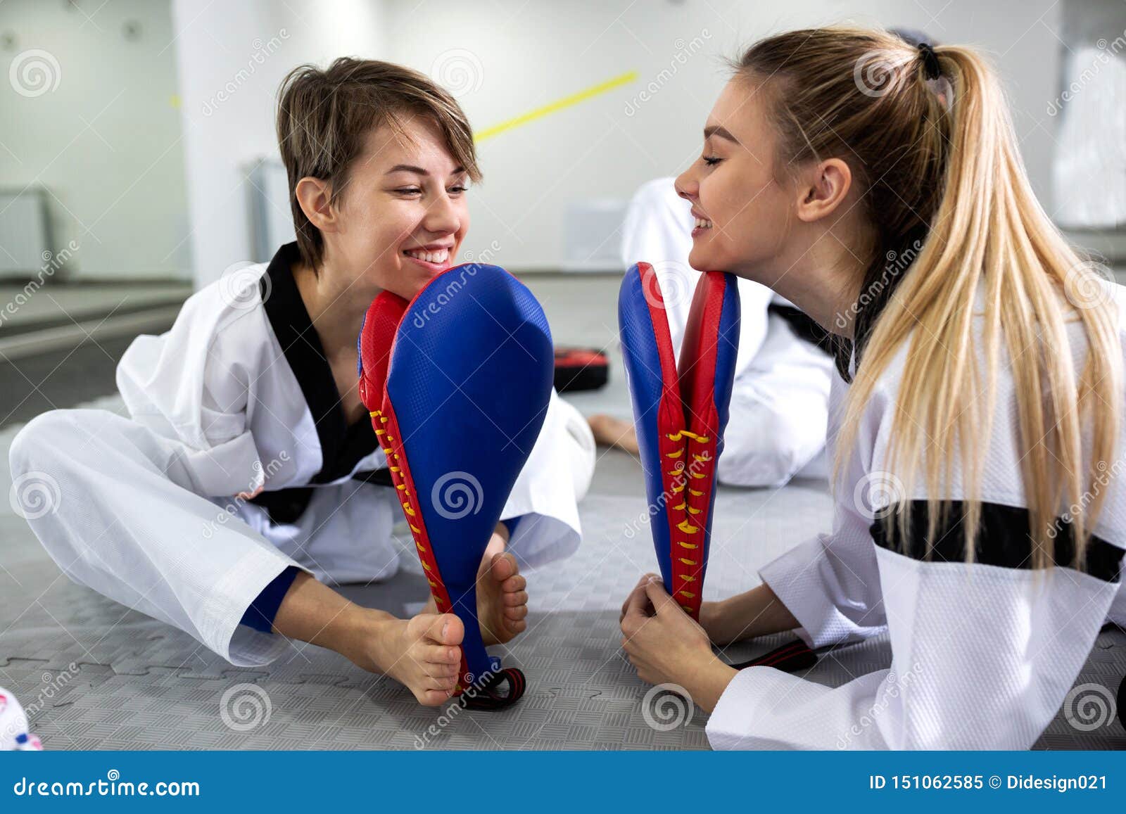 physically disabled martial art combat fighter and her friend holding a kick pad target
