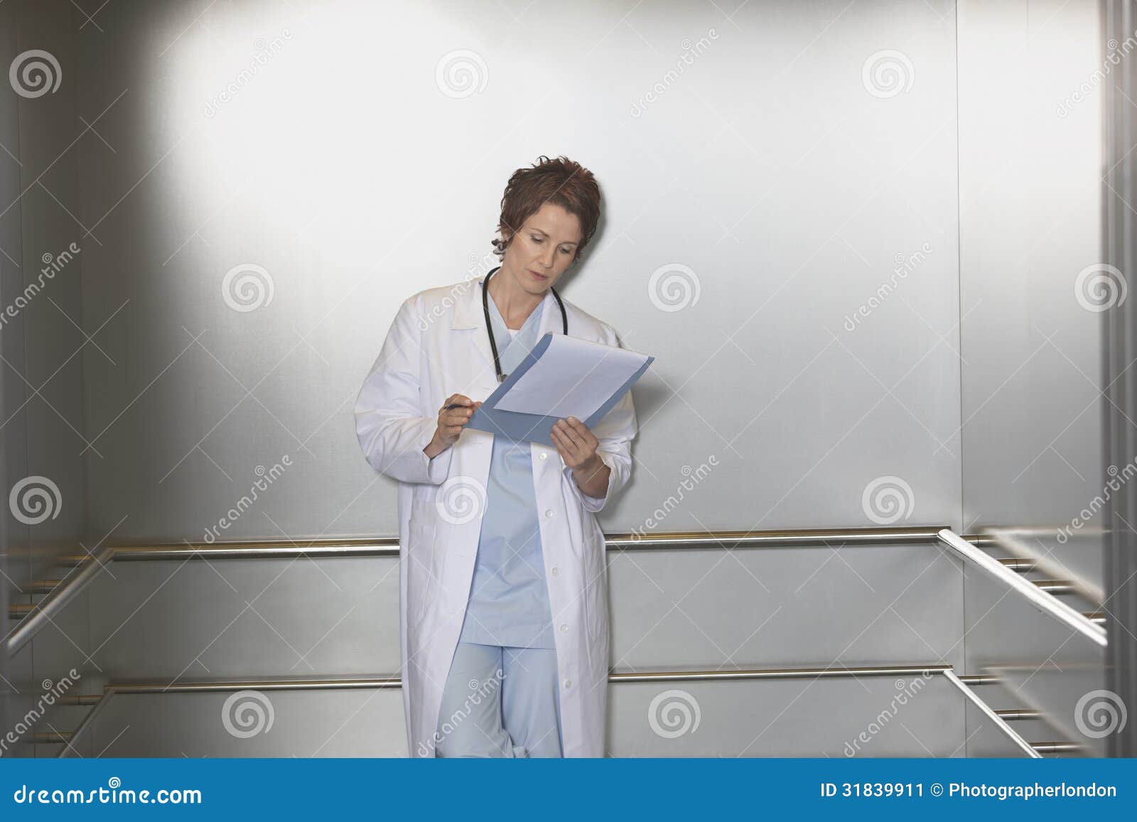 Physician Reviewing Notes in Elevator Stock Image Image of
