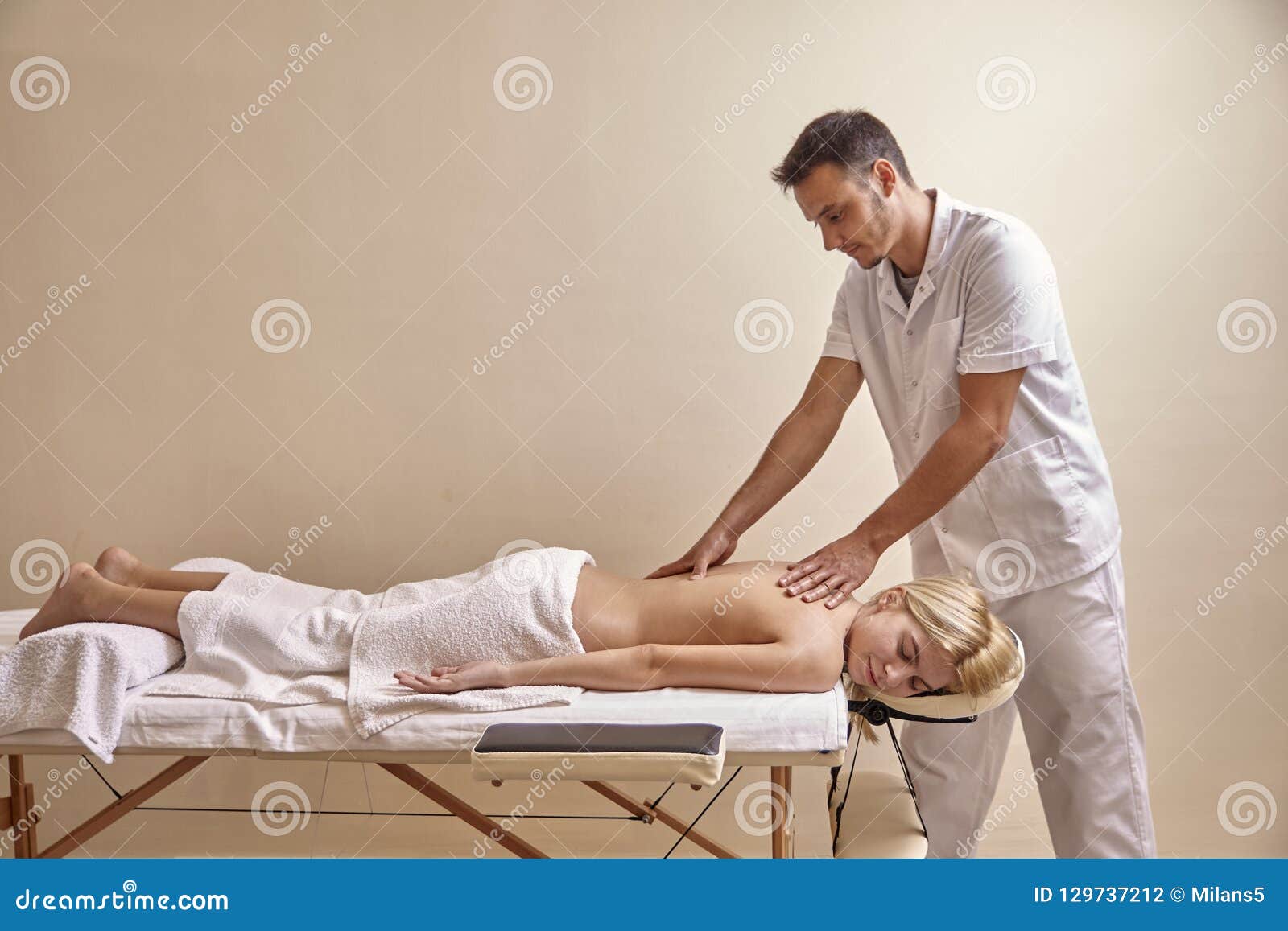 physiotherapist massage, woman back laying on bed. full lenght shot.
